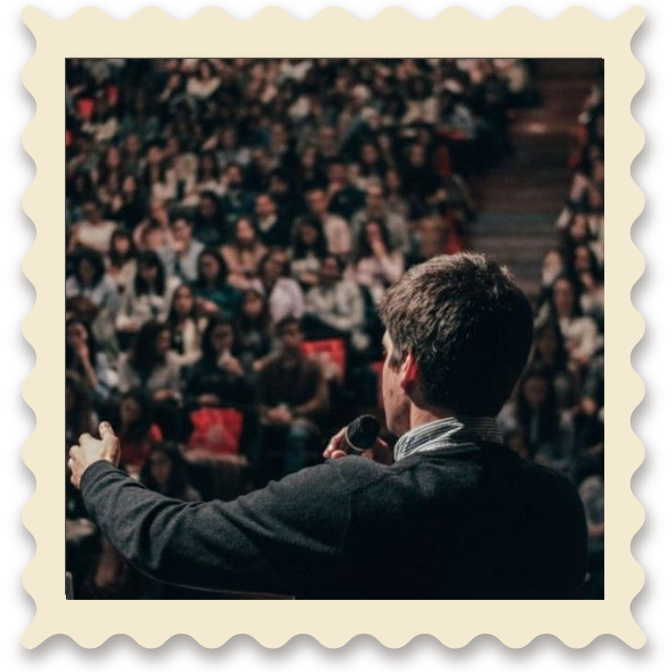 Un orador hablando frente a una audiencia en un escenario.