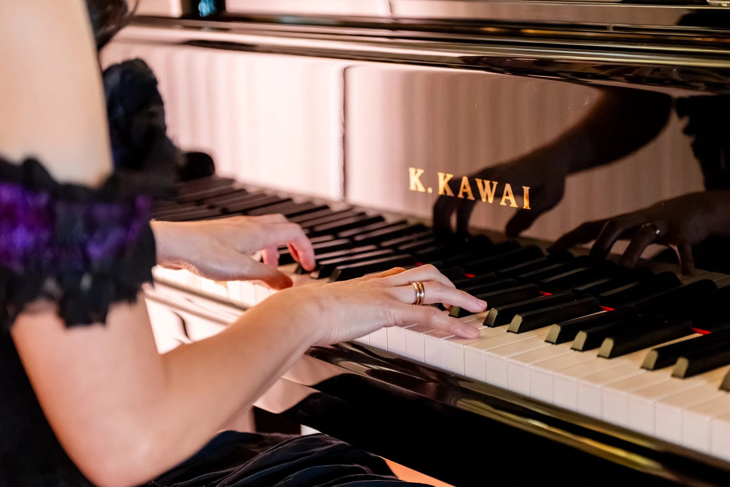Pianist's hands on the keys of the Kawai grand piano