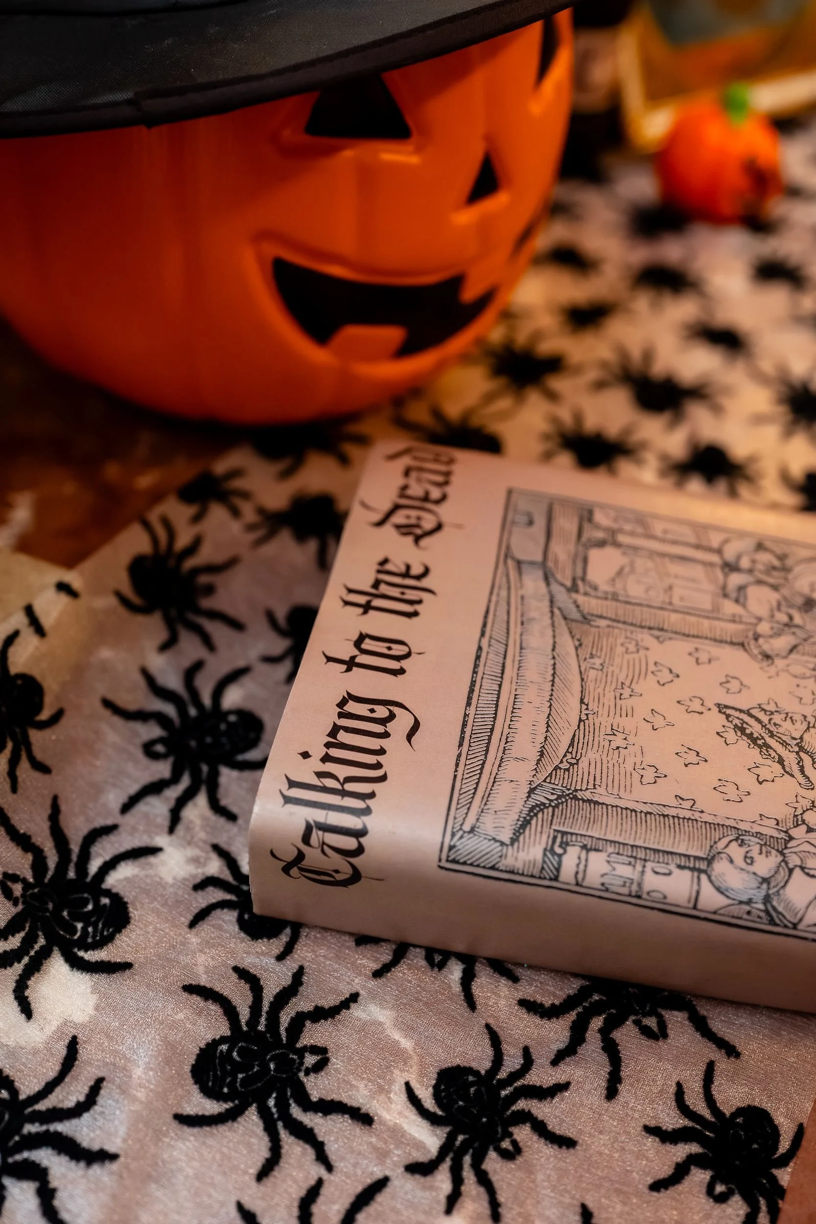 Jack-o'-lantern on a spider-print tablecloth at the reception