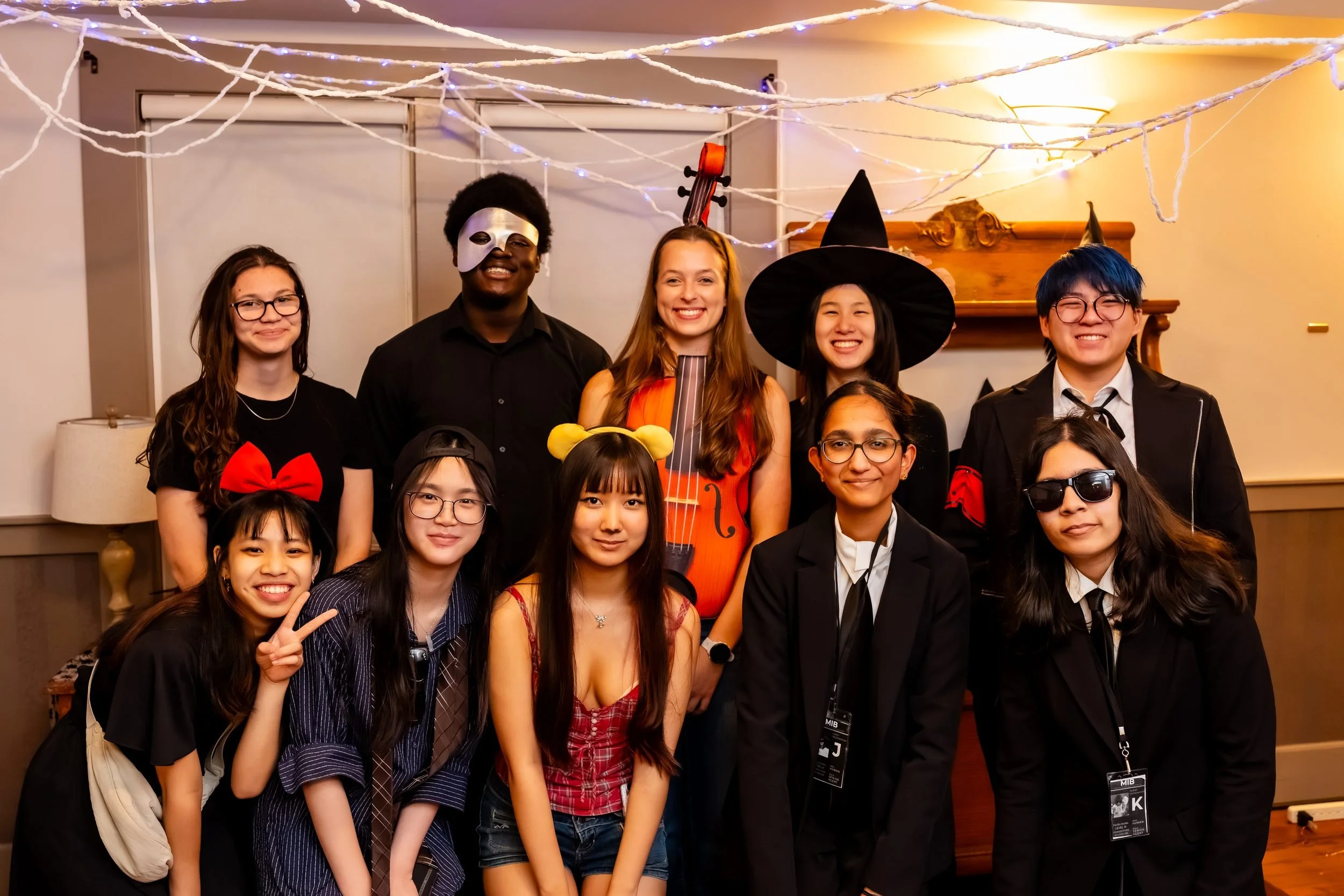 Students in Halloween costumes posing together at the reception