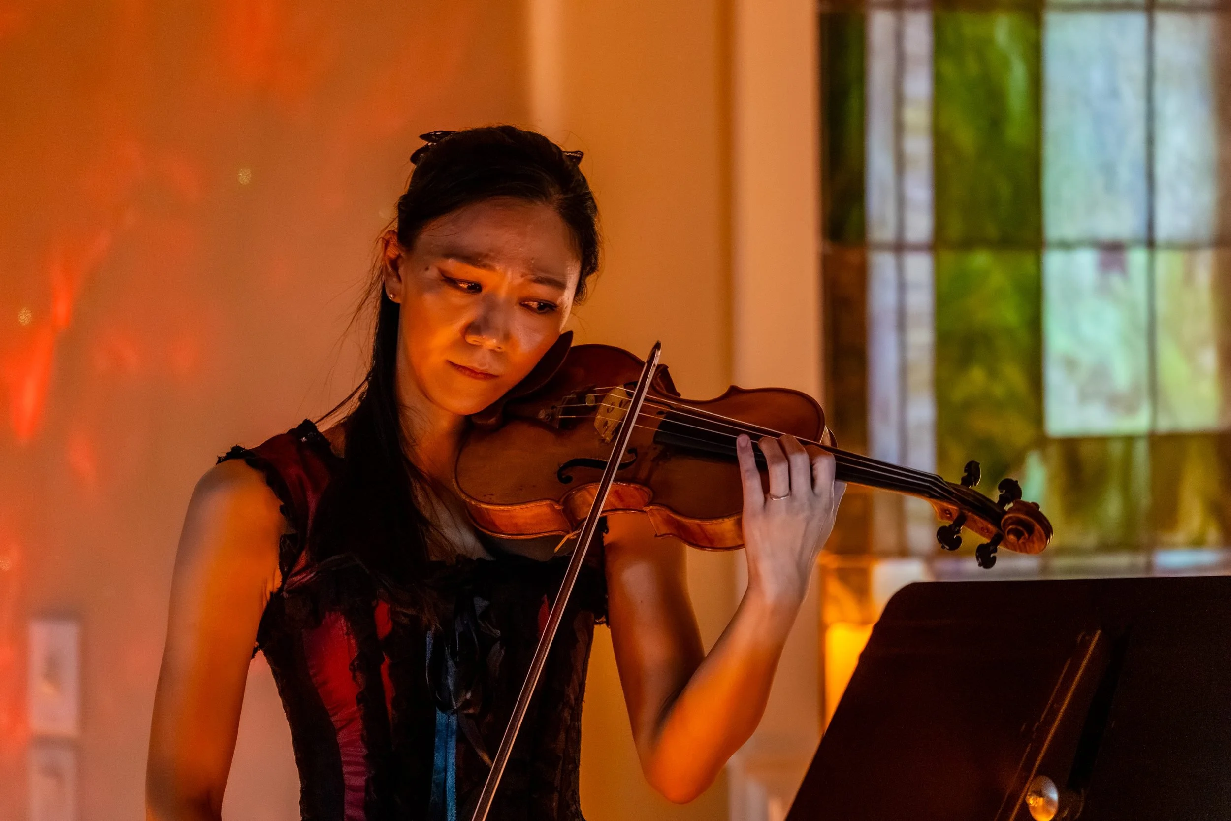 Violinist in close up under warm red light