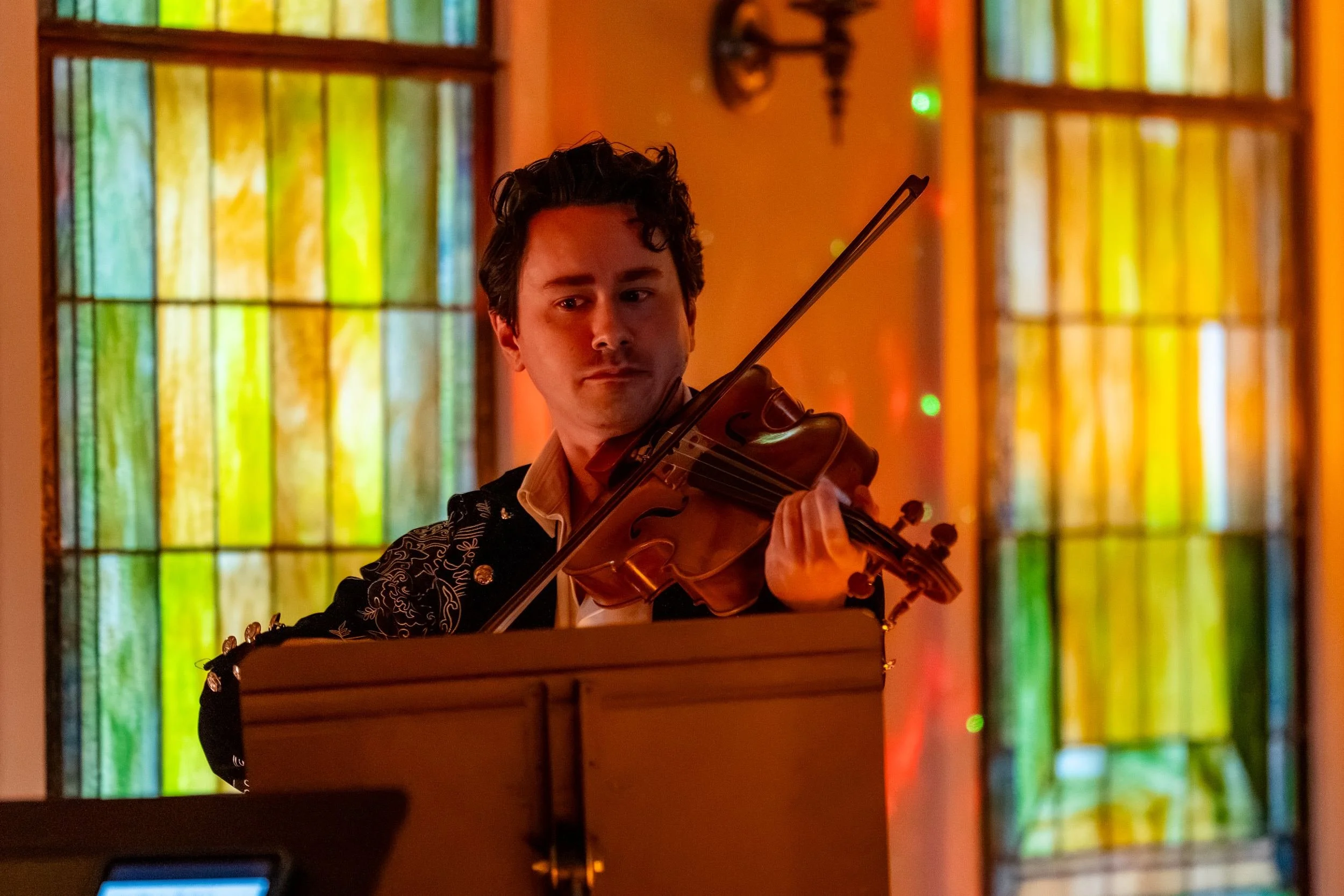 String player framed by a stained glass window