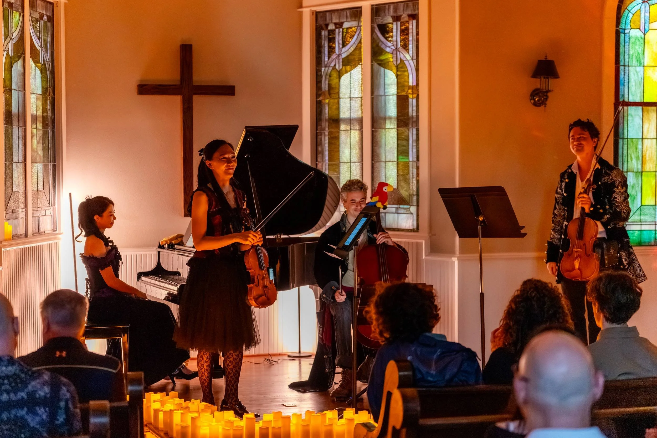 Quartet performing beneath the chapel cross, audience in the pews