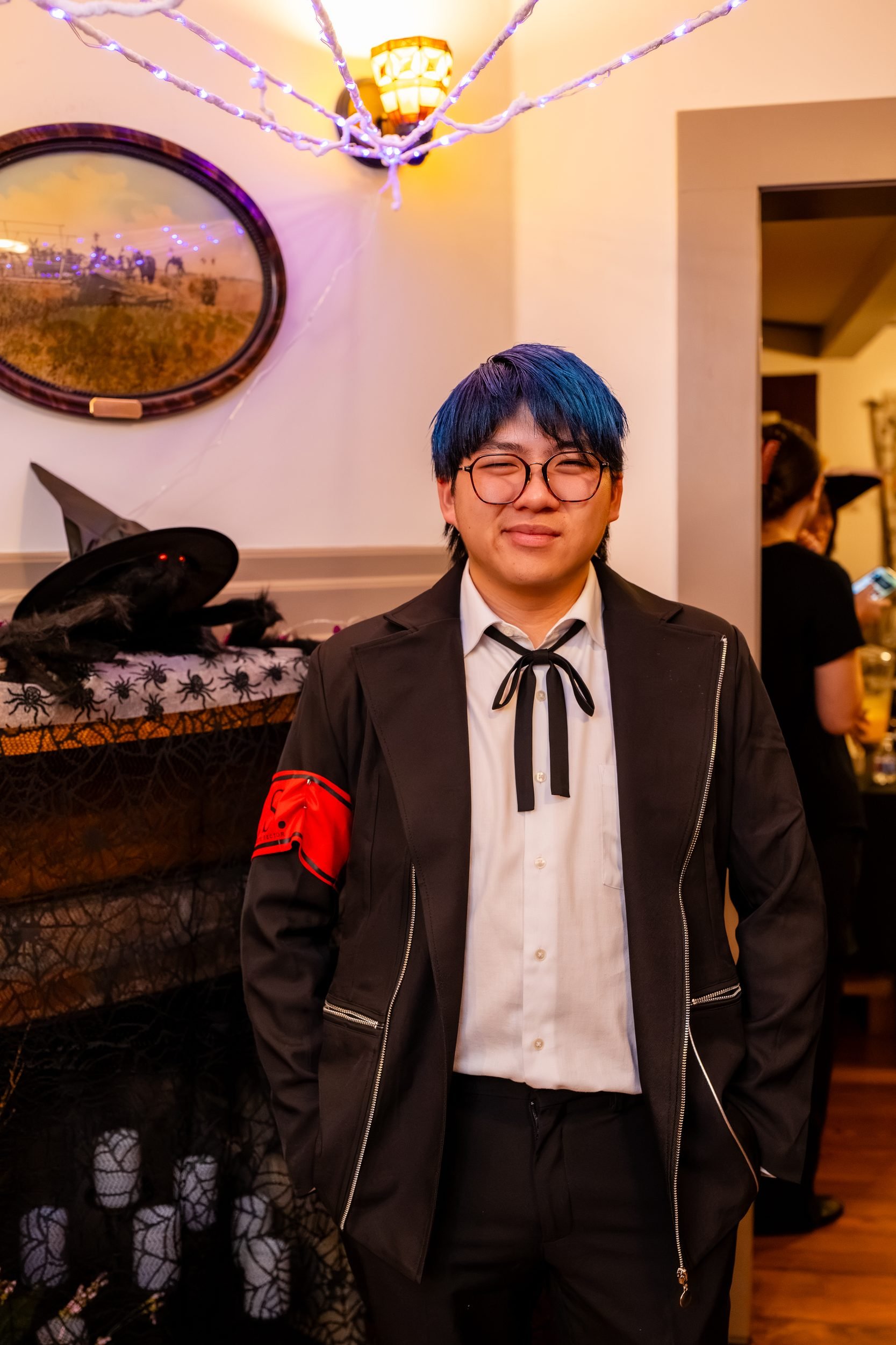 Student in a dark suit and blue wig at the reception