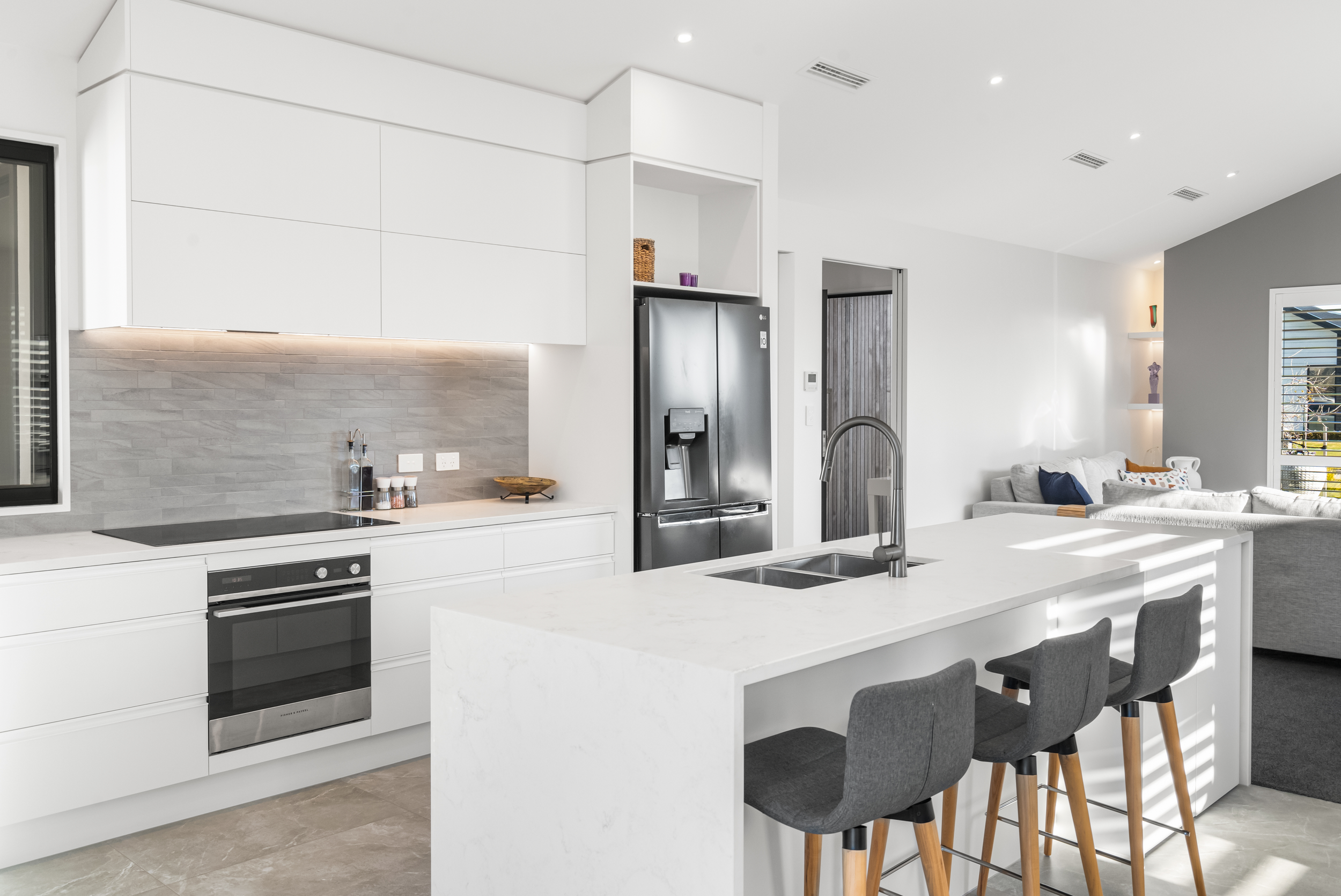 Custom built kitchen with stone 'water fall' bench tops and tiled floor and splashback located in Lincoln, Selwyn, Canterbury.