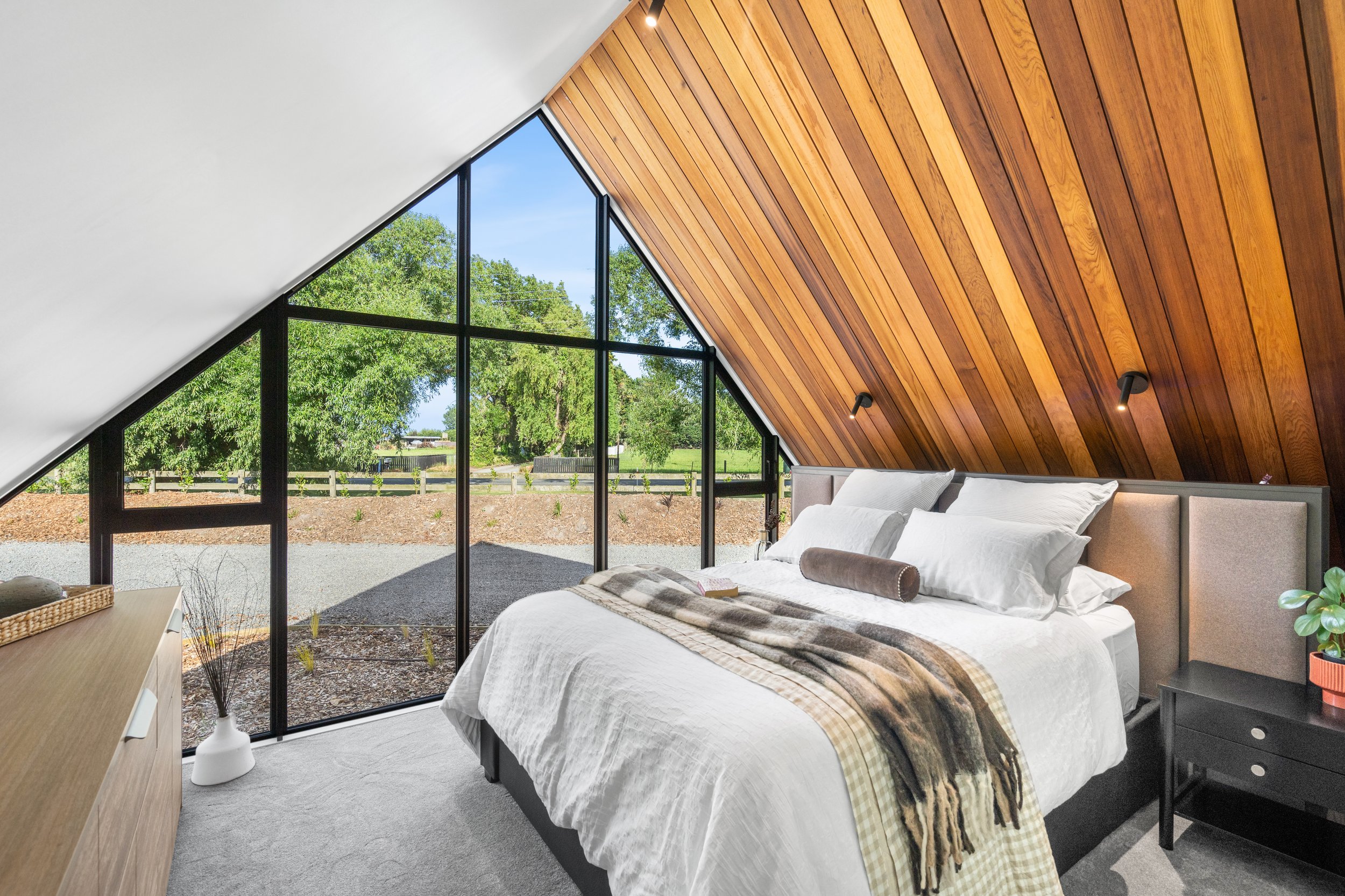 The Living Pod bedroom, with floor to ceiling window  overlooking the lake, South Island, NZ