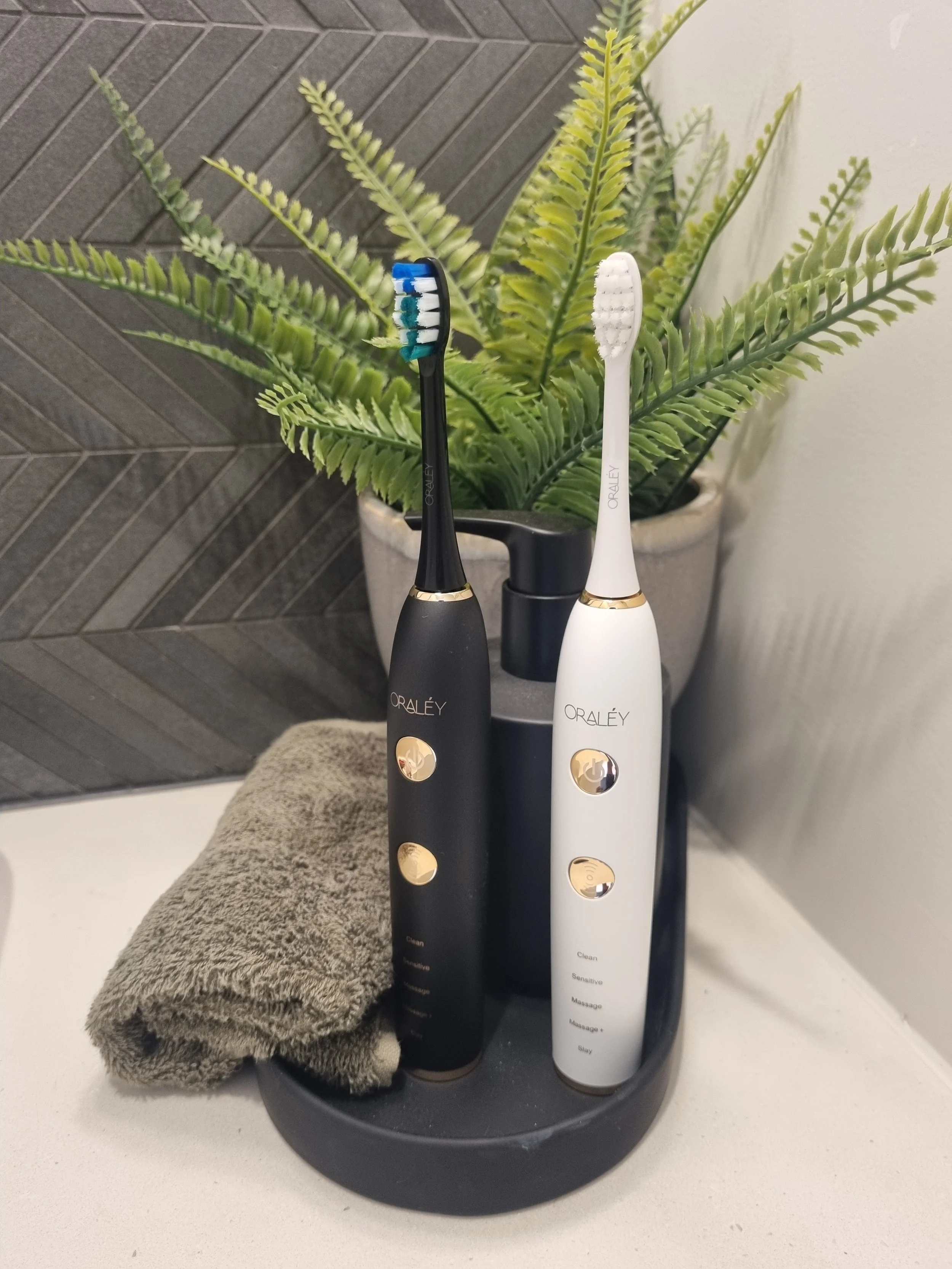 Black and White Oraley toothbrushes side by side