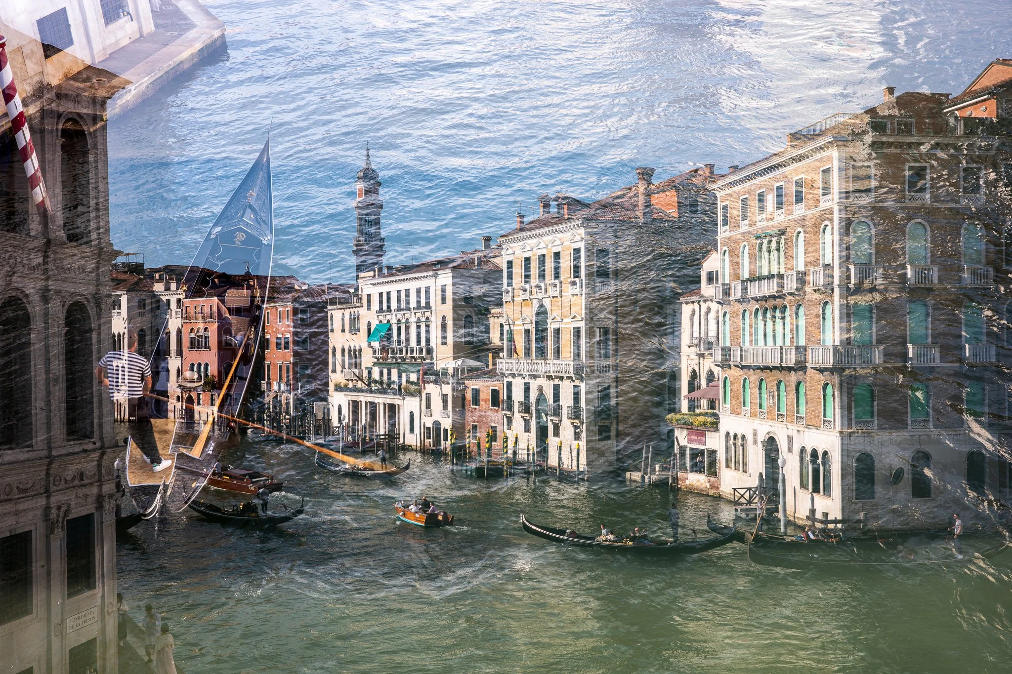 A double exposure looking down the Grand Canal from the Rialto Bridge, lined with palazzi and busy with gondolas and boats, overlaid with a gondola's prow at the left and rippled water washing across the upper half of the frame.