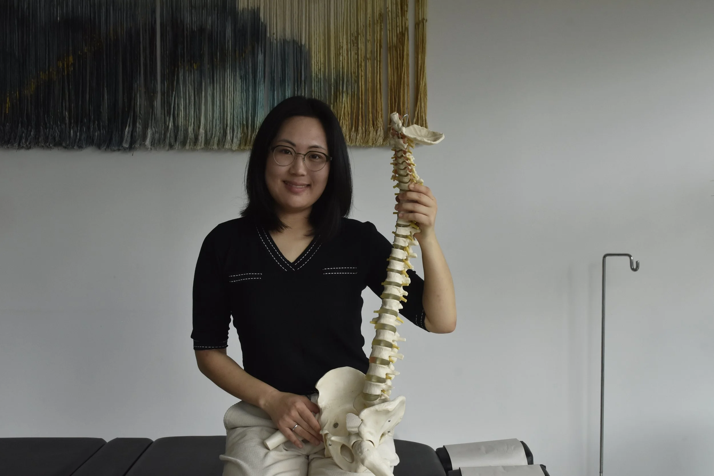 Dr Mia Ghil holding a spine model