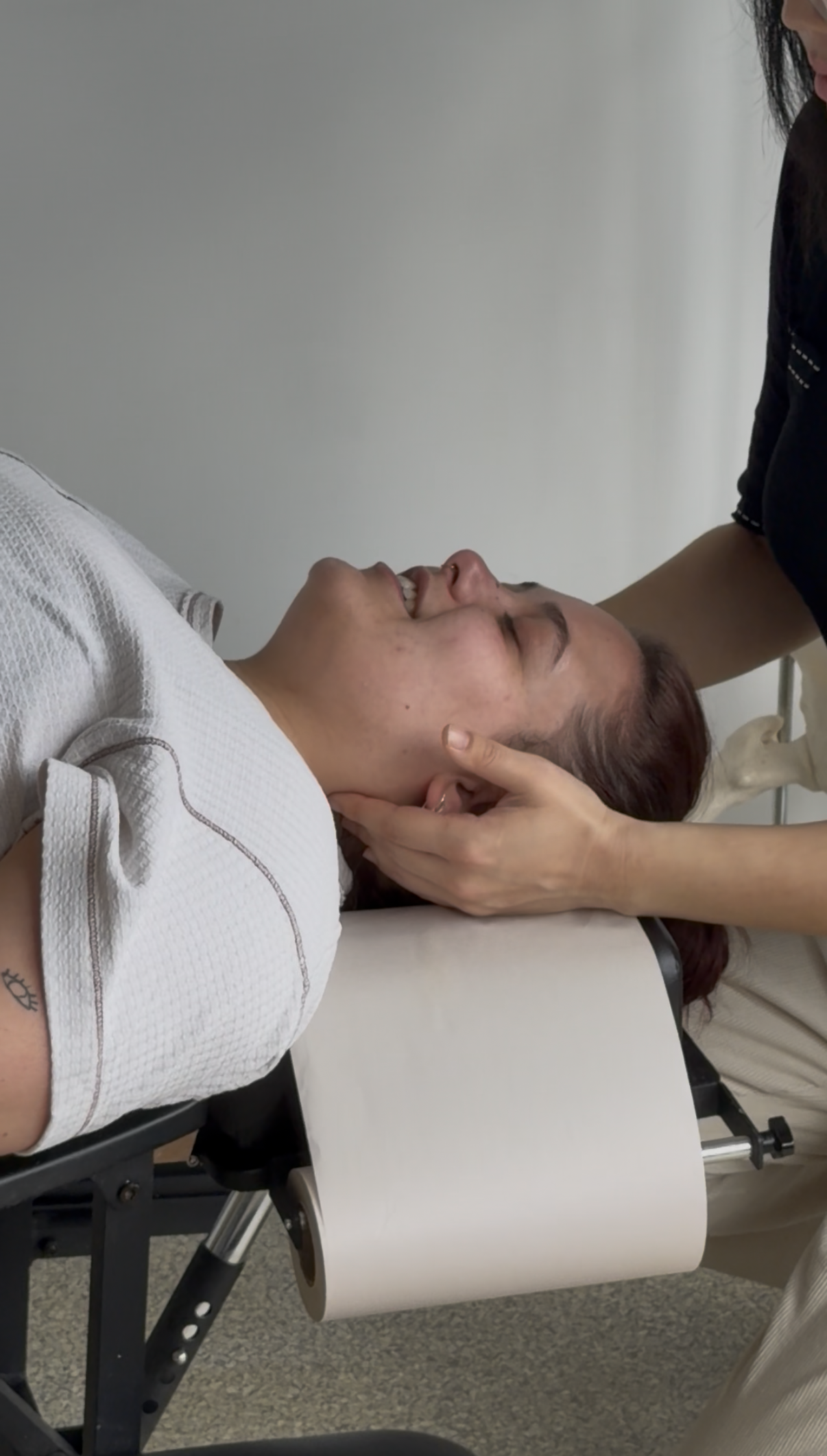 Chiropractor treating a patient's neck on the treatment table