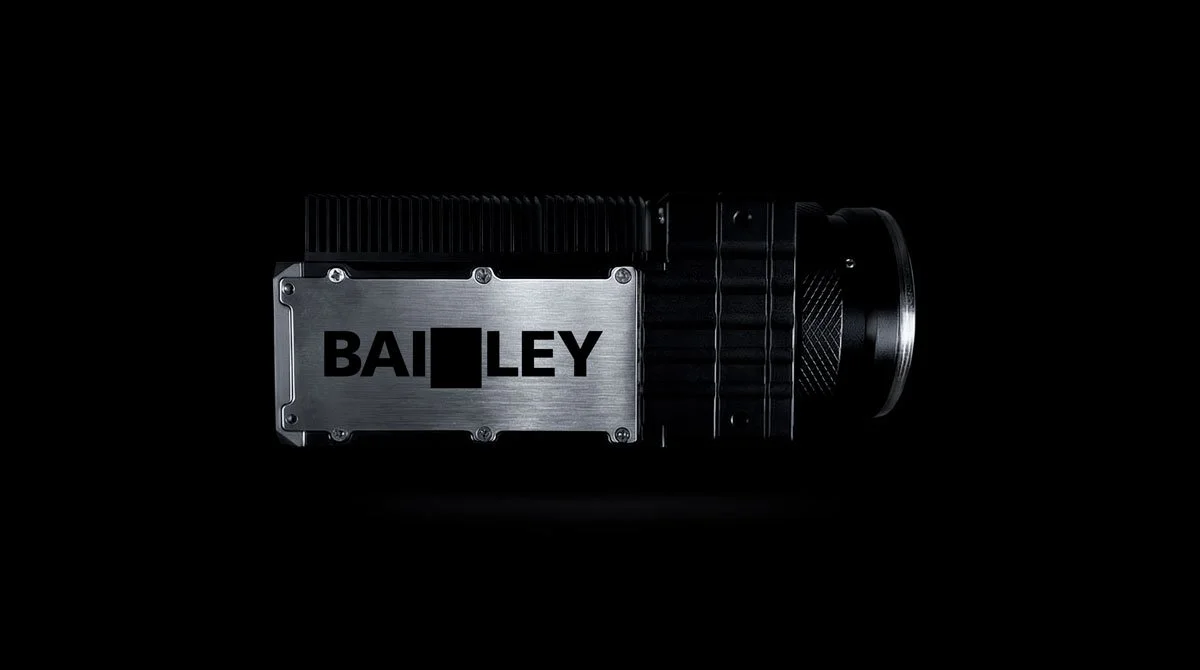 Close-up of a black and silver Bailey Camera System mechanical device with the brand name visible, set against a black background.