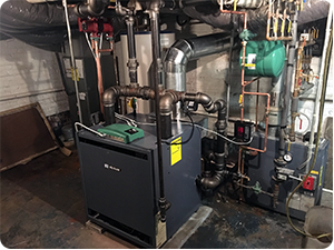 A boiler room with a large industrial boiler machine, pipes, and valves.