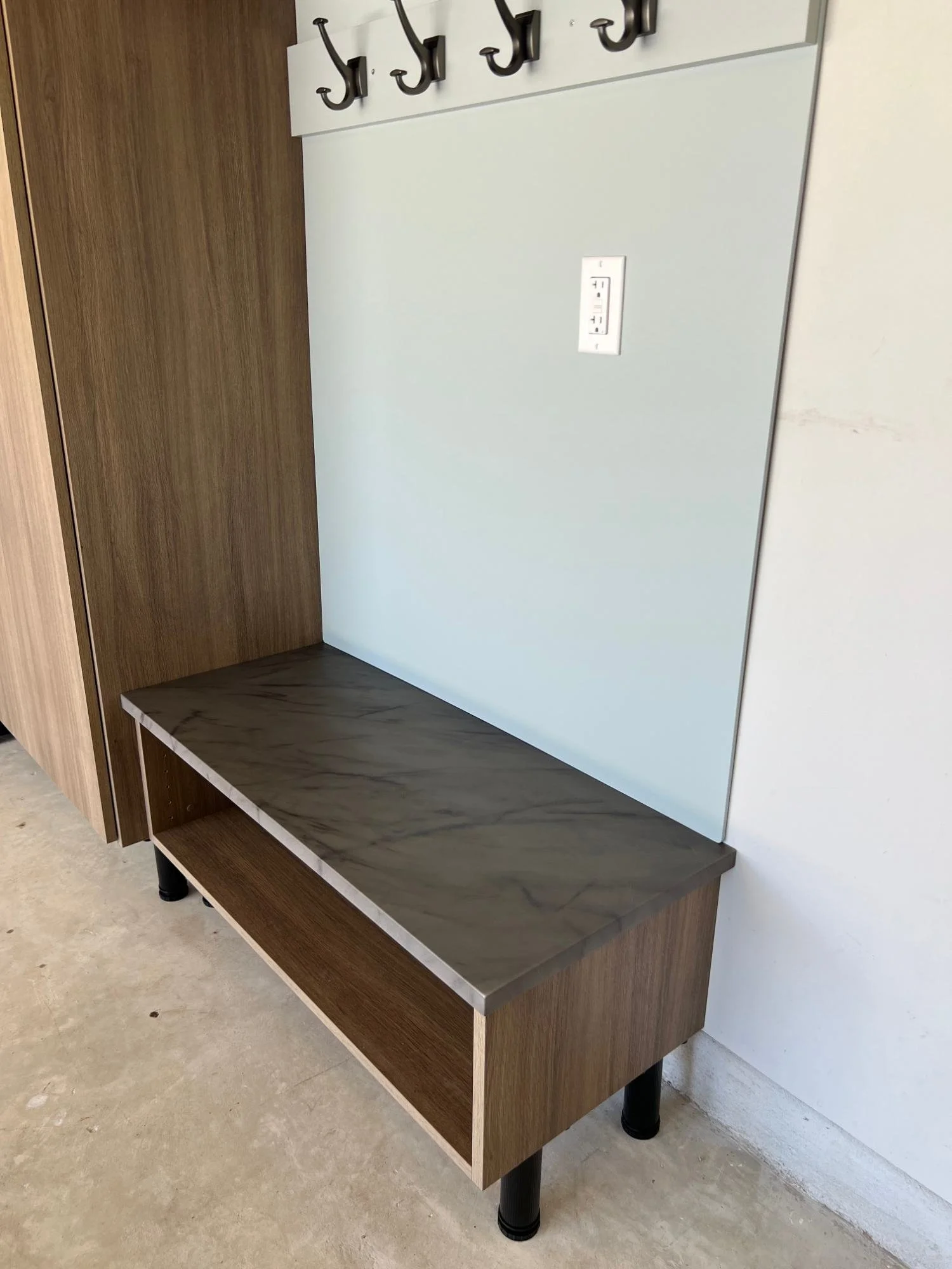 Drop zone bench with a gray marble-look top and an open shoe shelf below