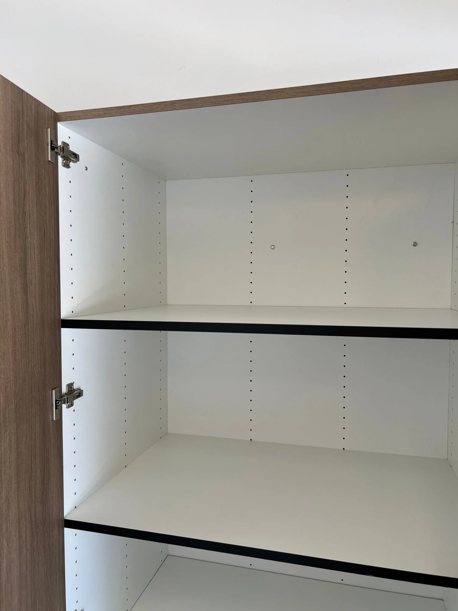 Inside a 24-inch-deep garage cabinet with adjustable shelves and a white interior