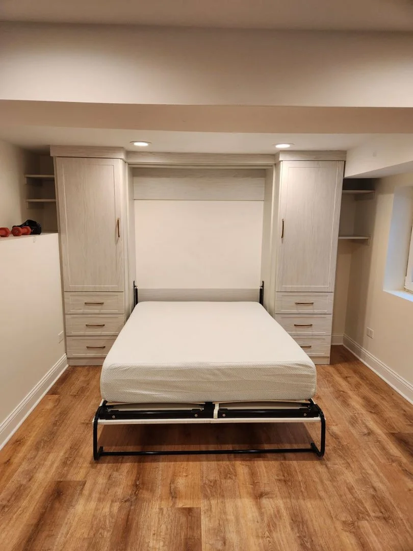 Wall bed, Murphy bed in the open position  winter fun with floor to ceiling drawers and cabinets flanking the bed and crown molding for a clean look.