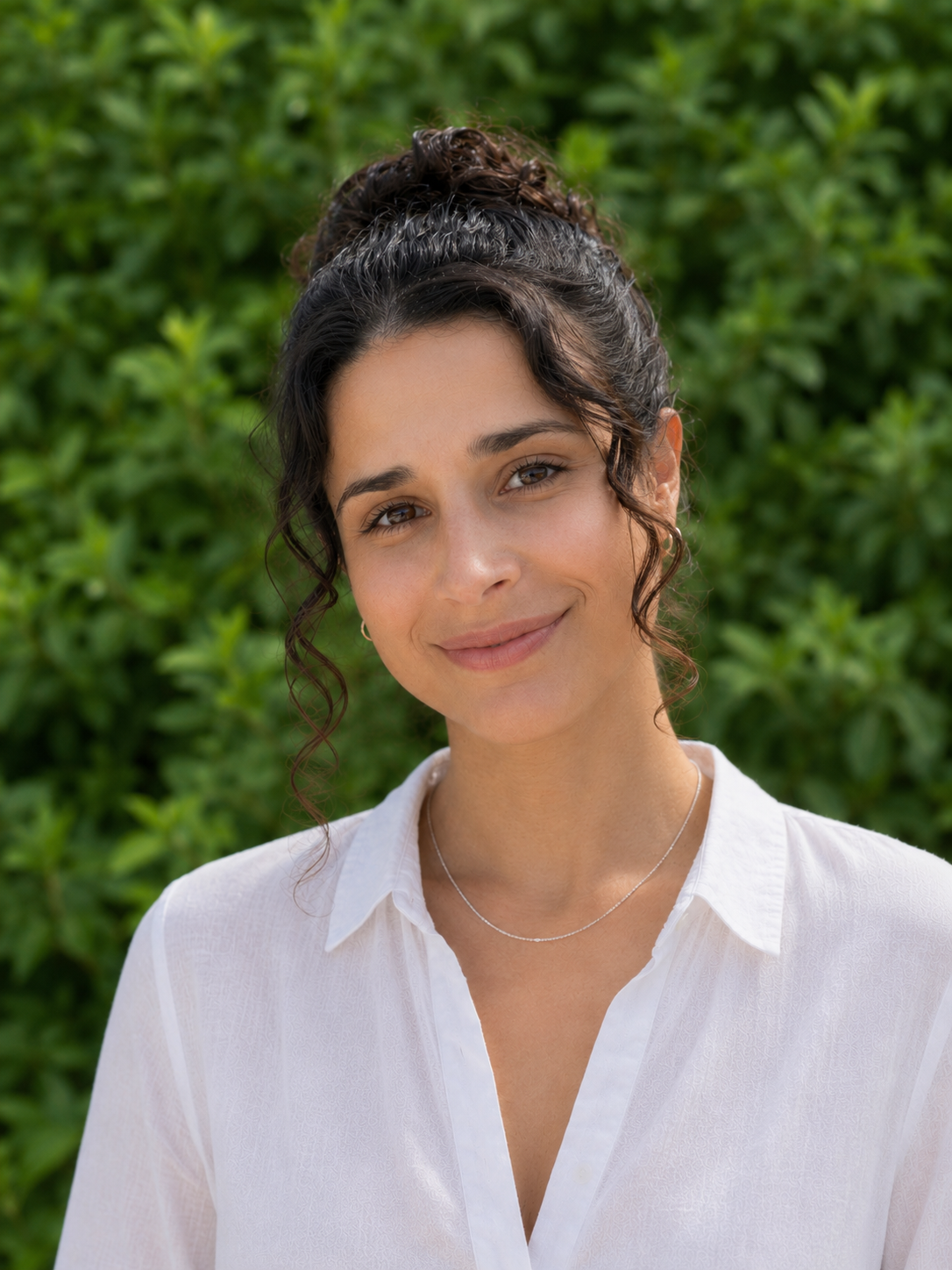 Becca Rosenberg smiling outdoors in front of greenery