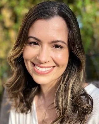 Professional headshot of Elise smiling outdoors