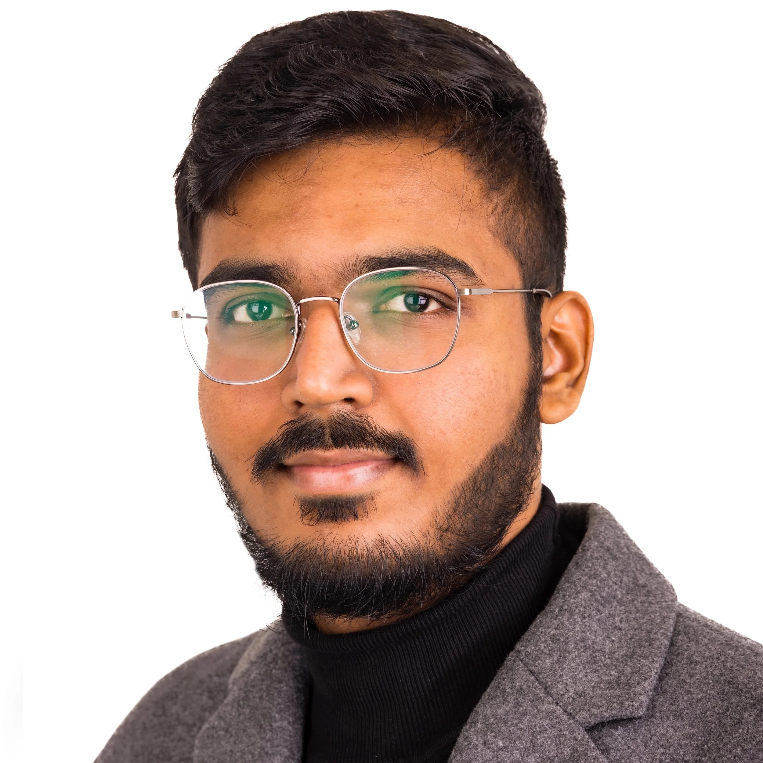 Man wearing glasses and a gray jacket on a white background.