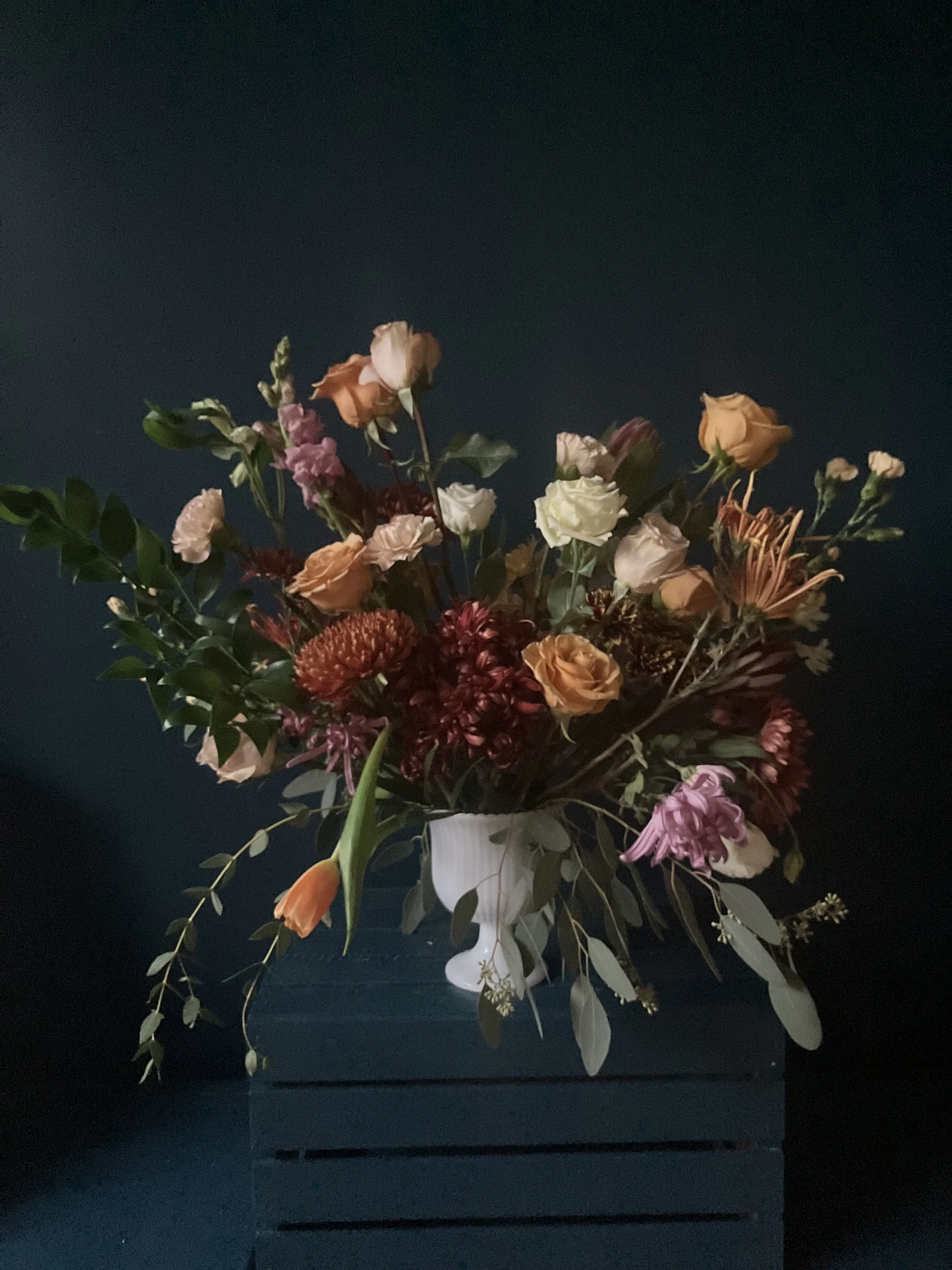 A big arrangement of mums, snapdragons and roses in a vase for Thanksgiving gift