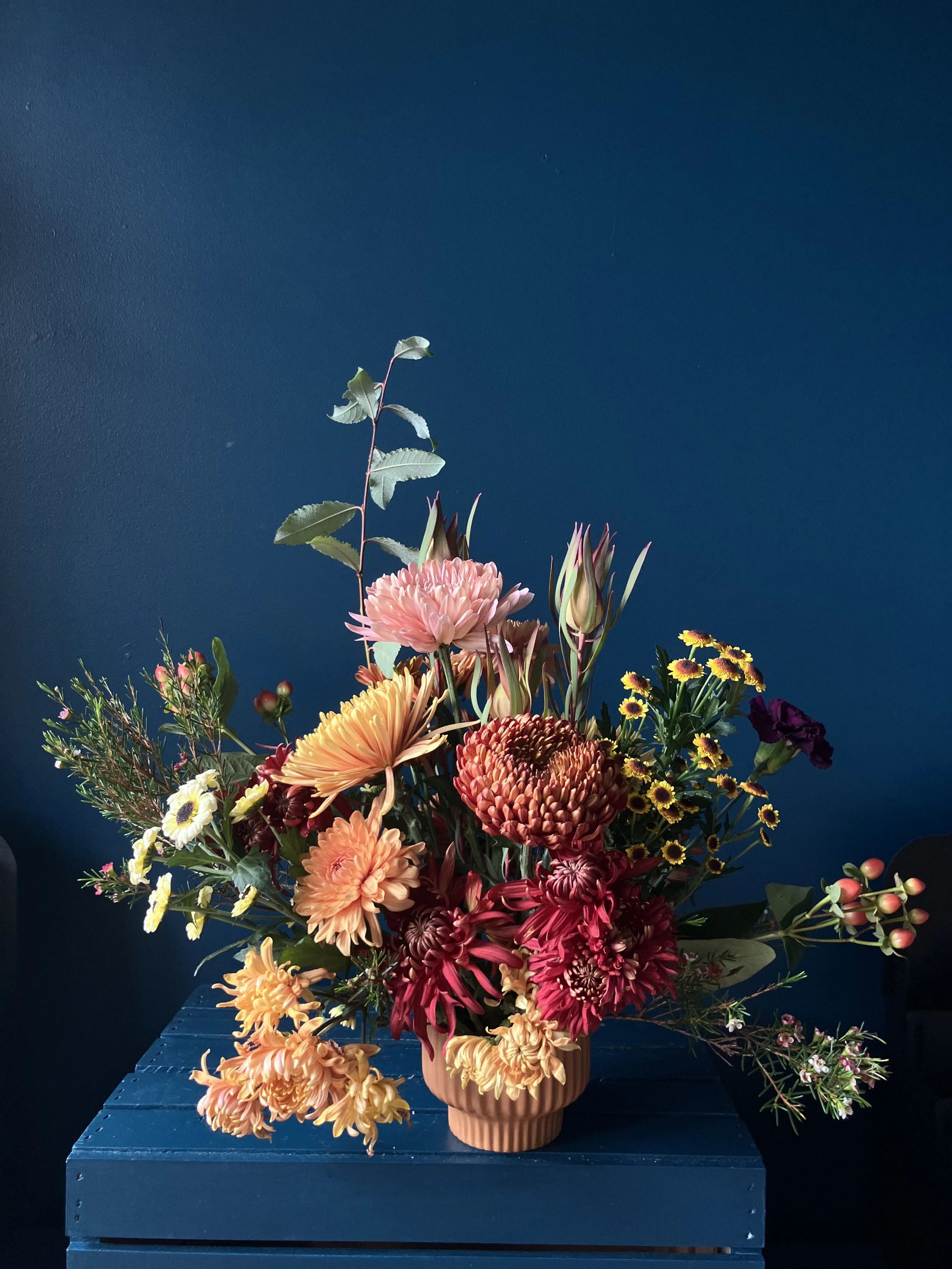 Low and compact version of our Thanksgiving flowers designed with mums and foliages