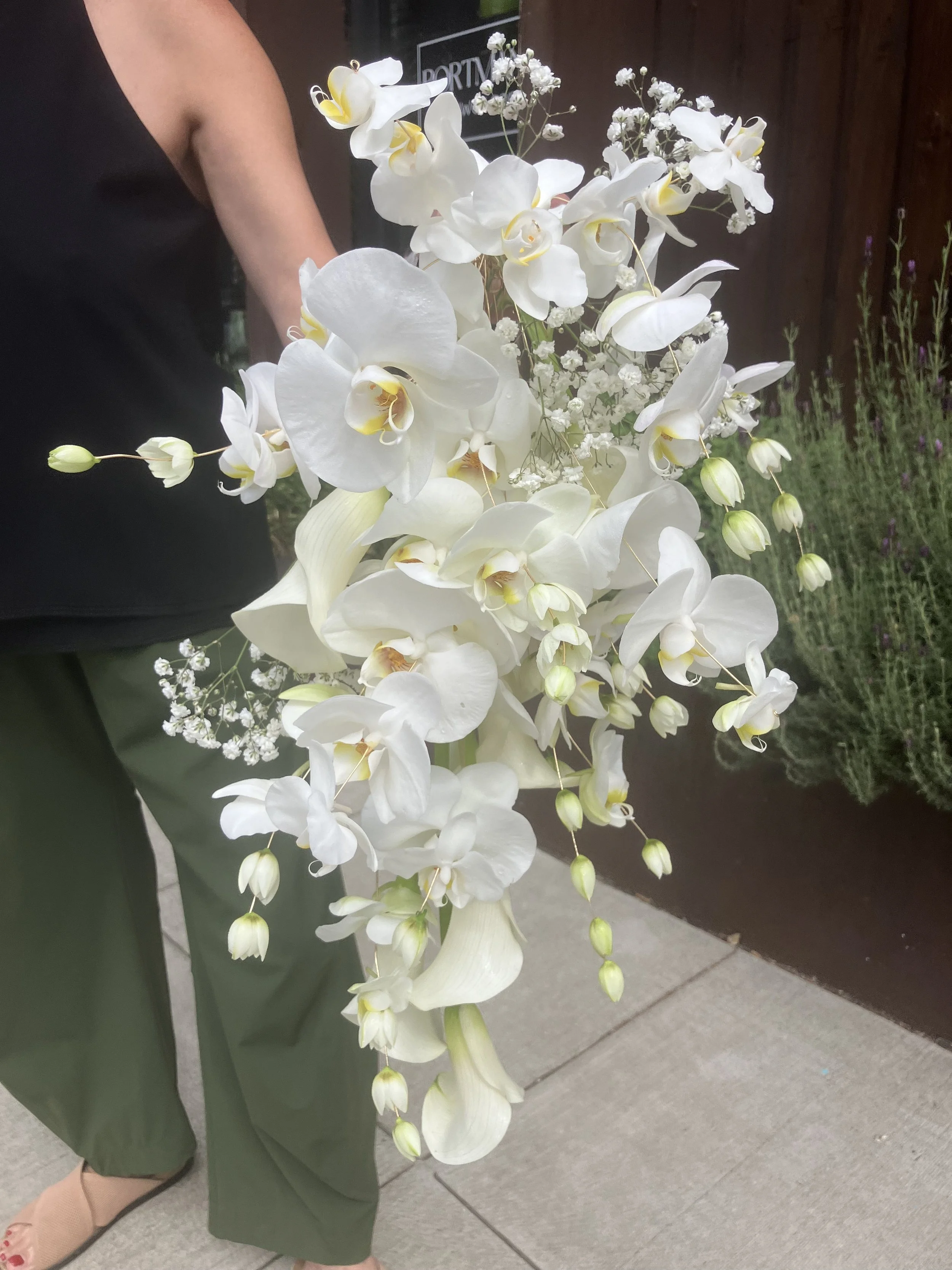 A cascading bridal bouquet of moth orchids and calla lilies designed for a Portland Oregon wedding using a wiring technique, by Portmanteau Flower Co