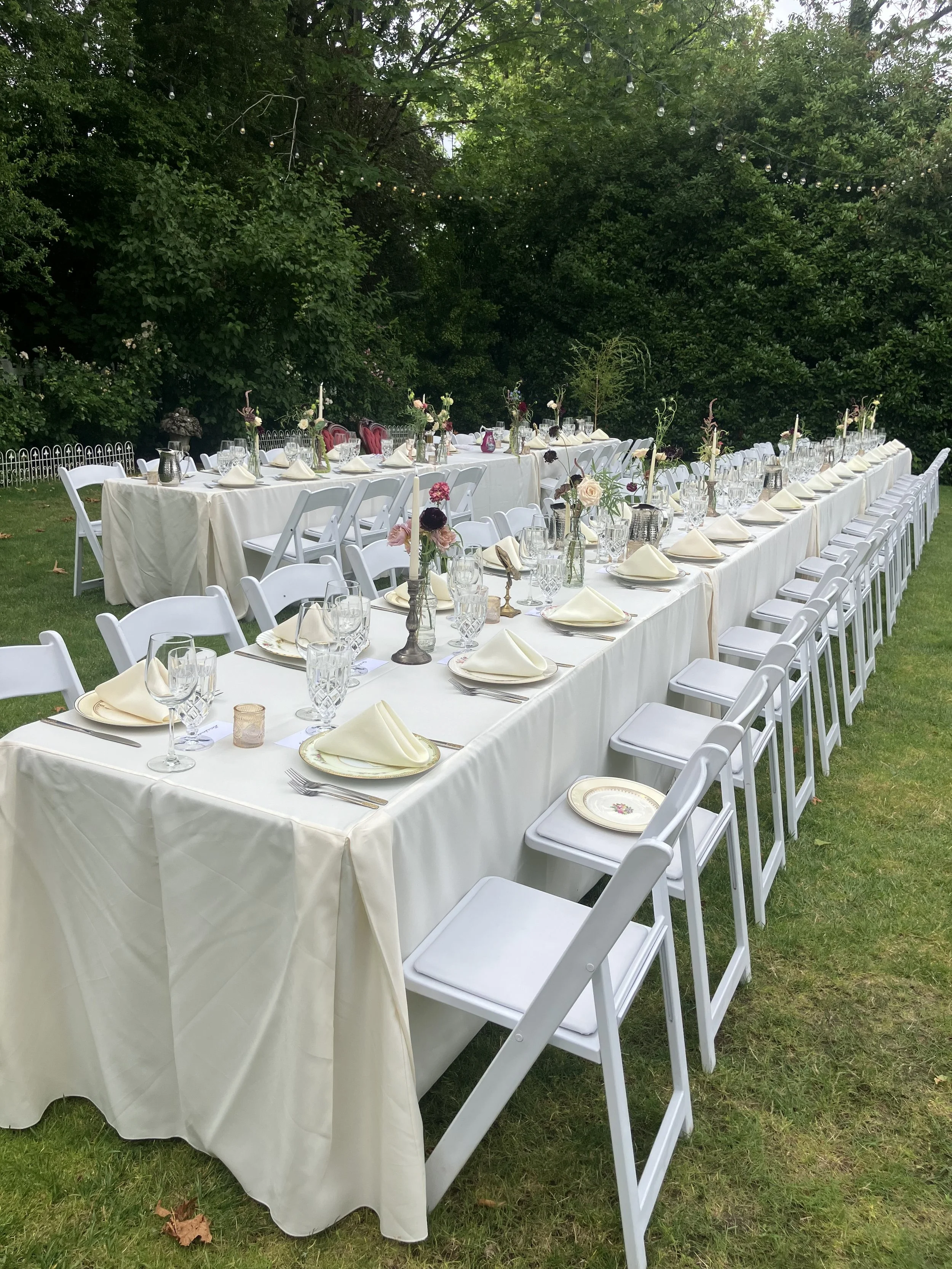 Wedding table with place settings and flowers in bud vases designed for a Portland wedding and reception outdoors
