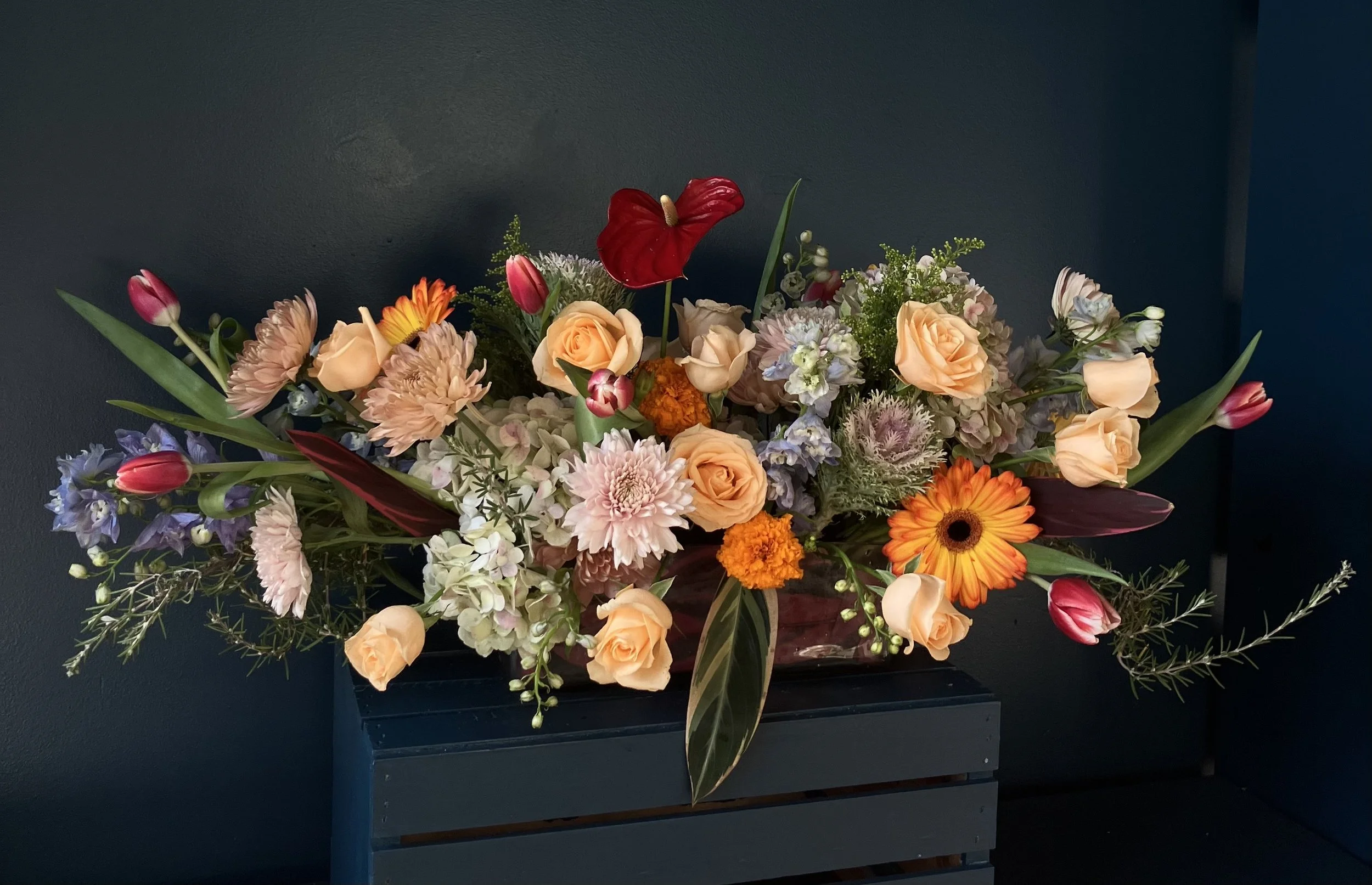 Lush, low floral arrangement by a Portland florist with horizontal movement in a low vessel, with neutral colors