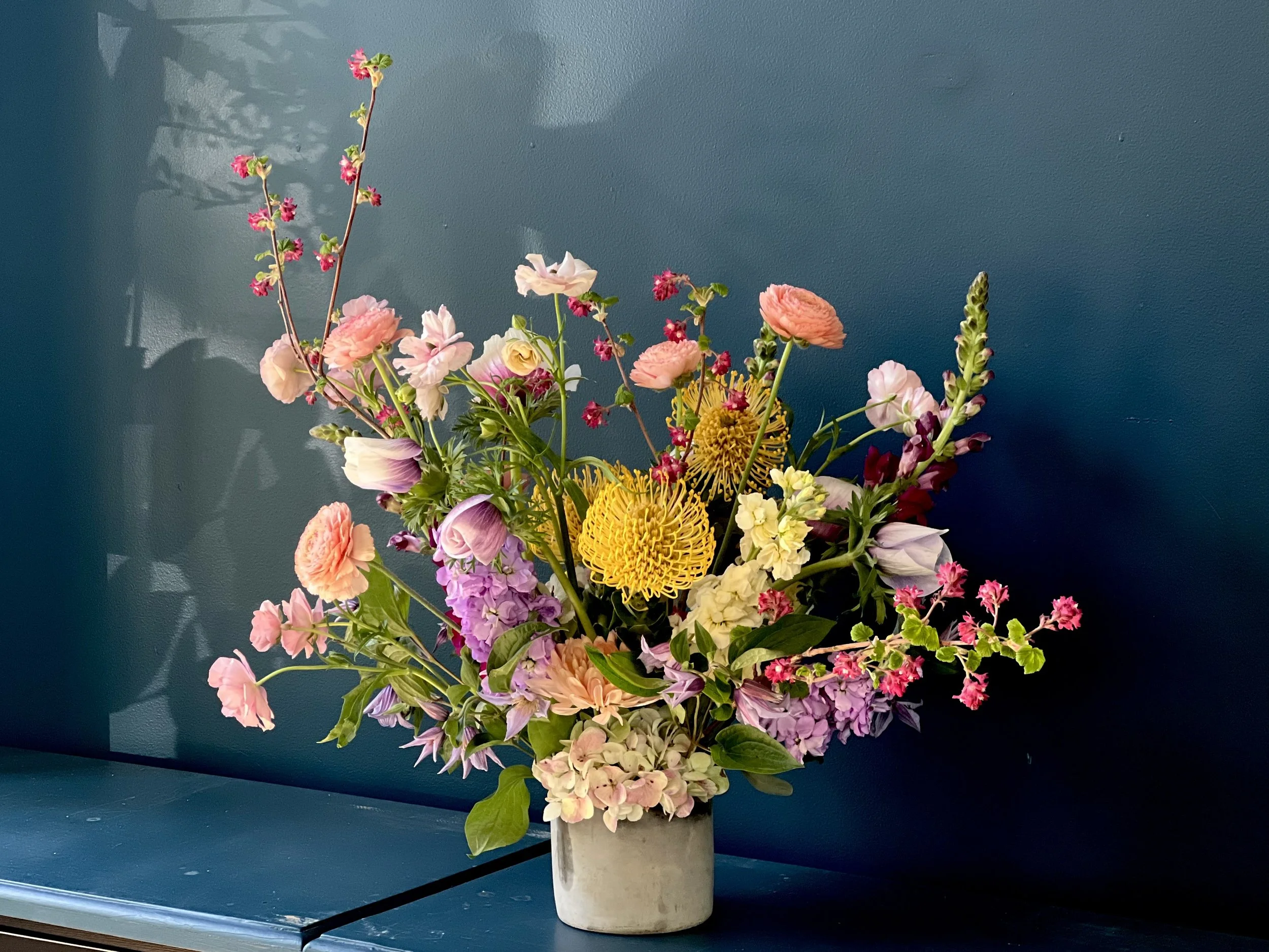Luxury spring flower arrangement with hydrangea, ranunculus, snapdragons, and protea in glass vase for Mother’s Day delivery in Portland OR