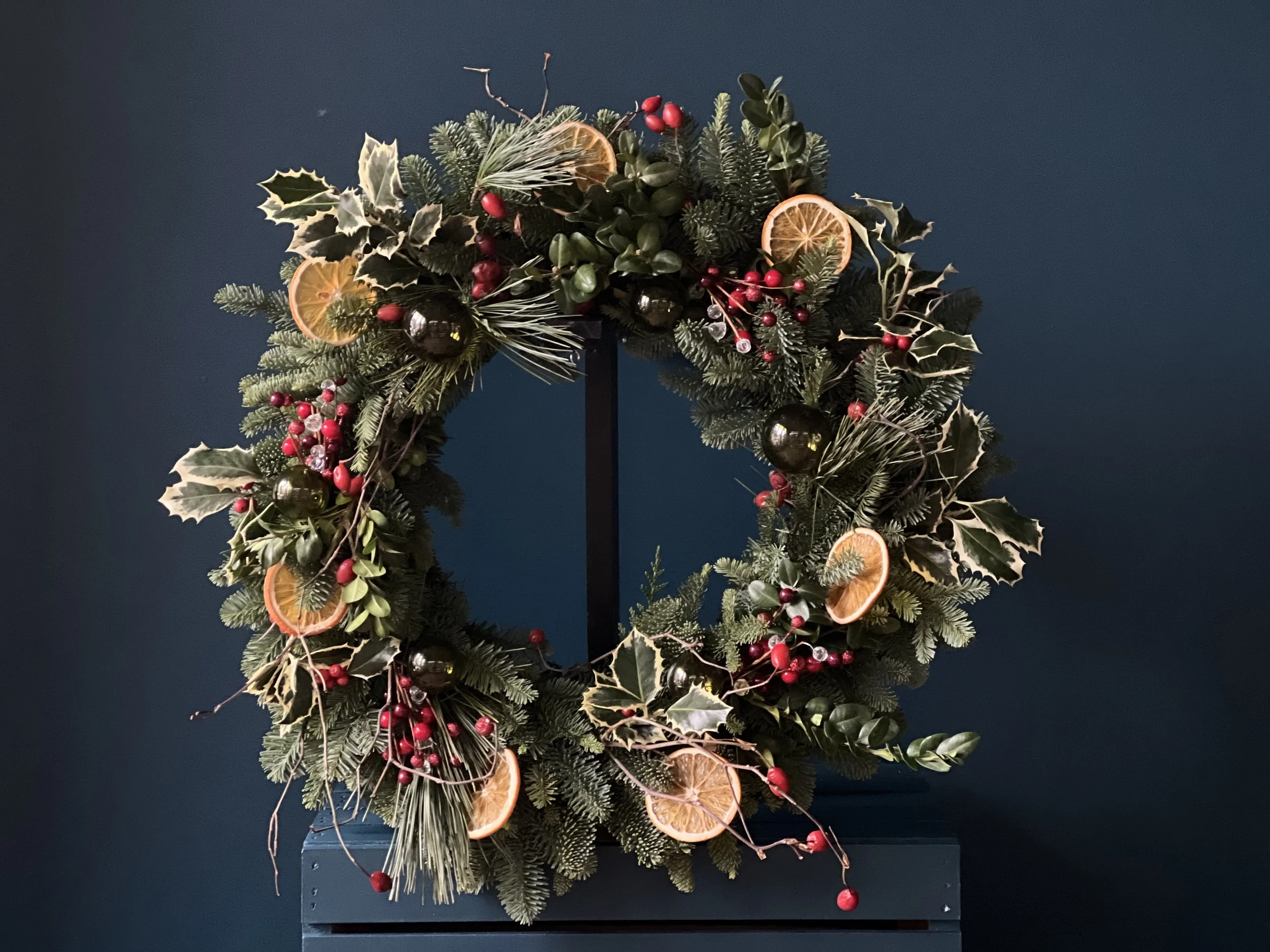 A beautiful circle wreath for the holidays made of living greens and dried elements
