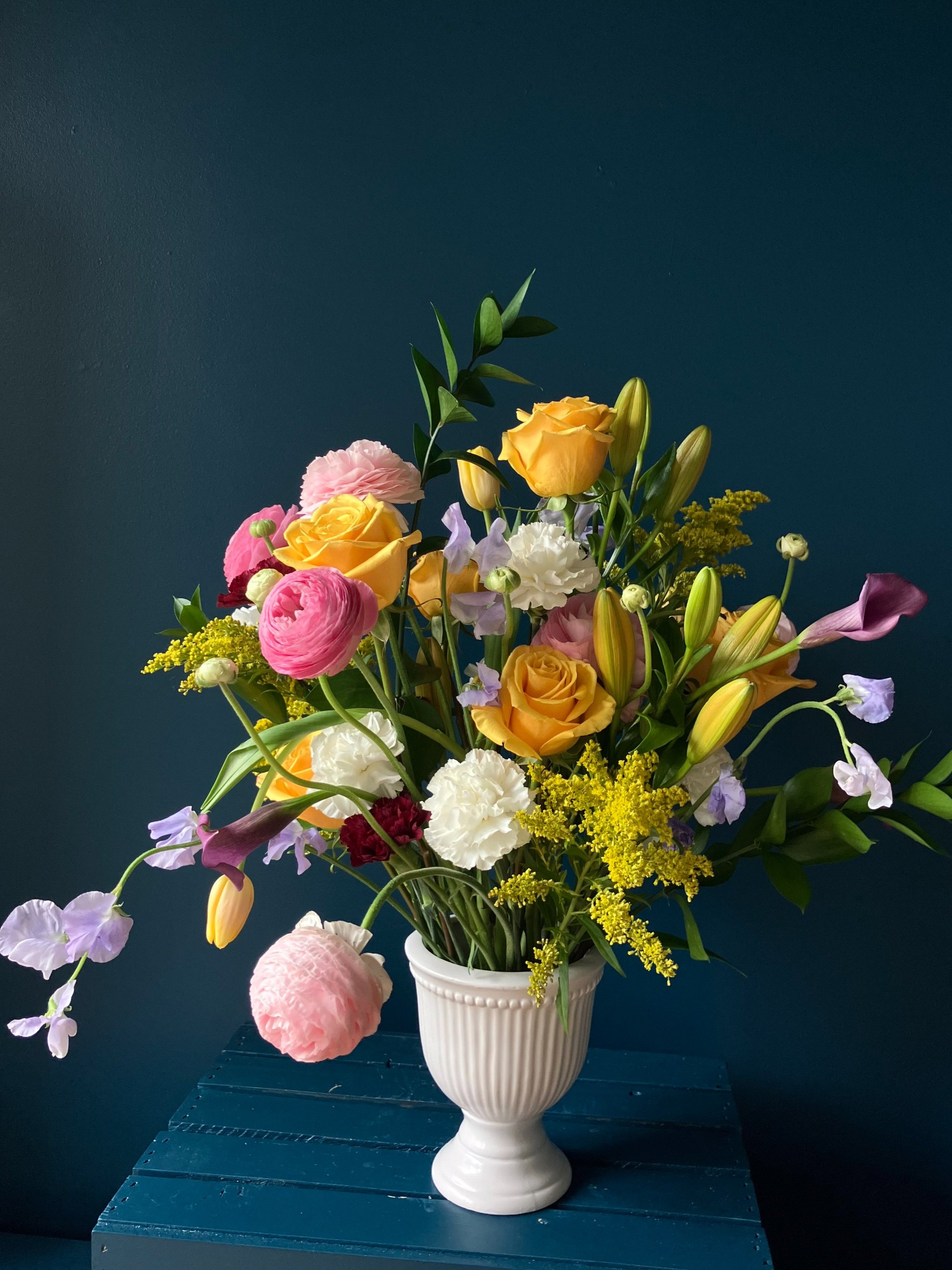 Our Mother's Day arrangement in hues of pink ranunculus, yellow roses, purple callas and peas with carnations & lilies & tulips