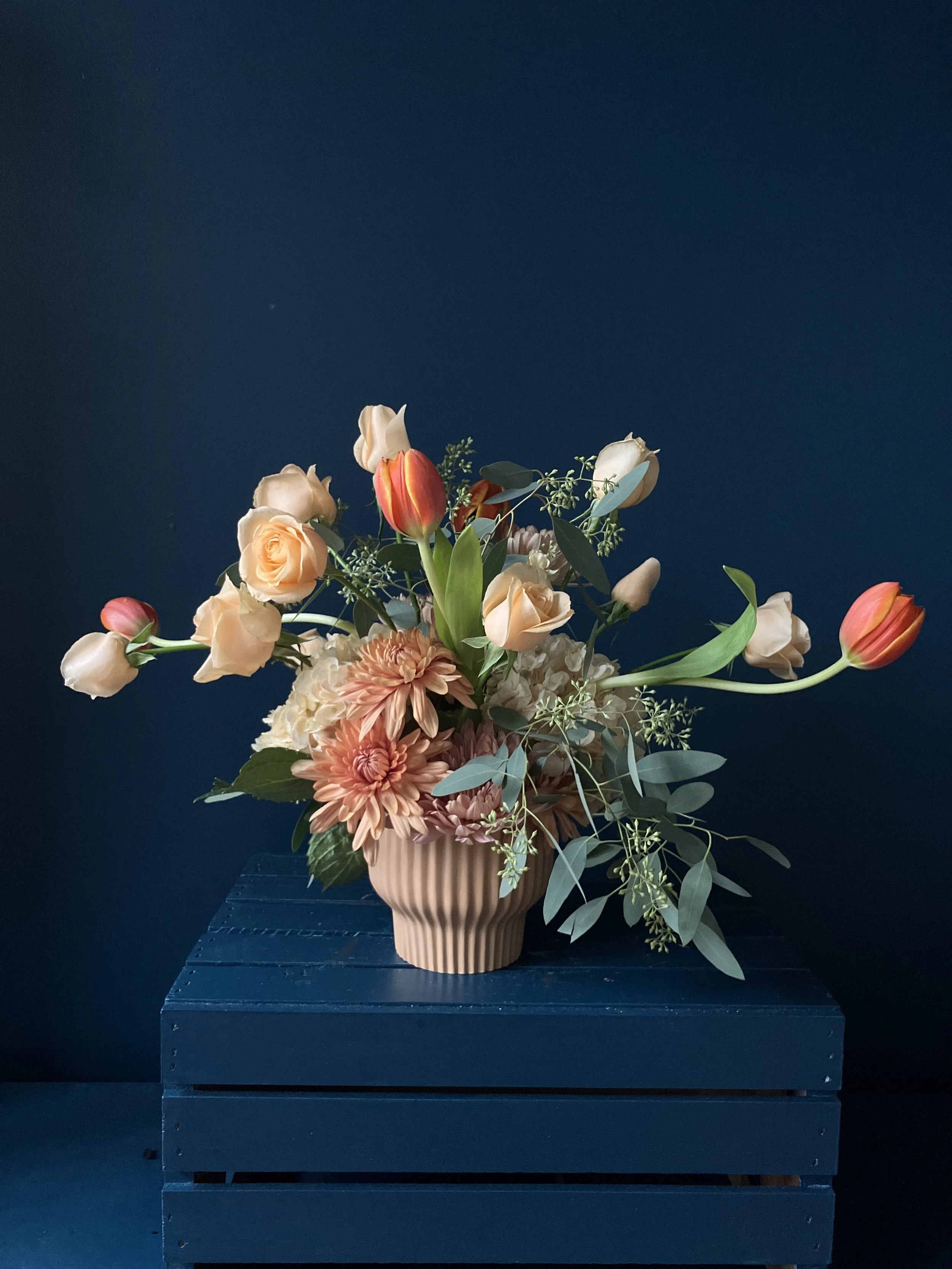 Seasonal arrangement for our flower subscription club that uses peach roses, fall mums and orange tulips
