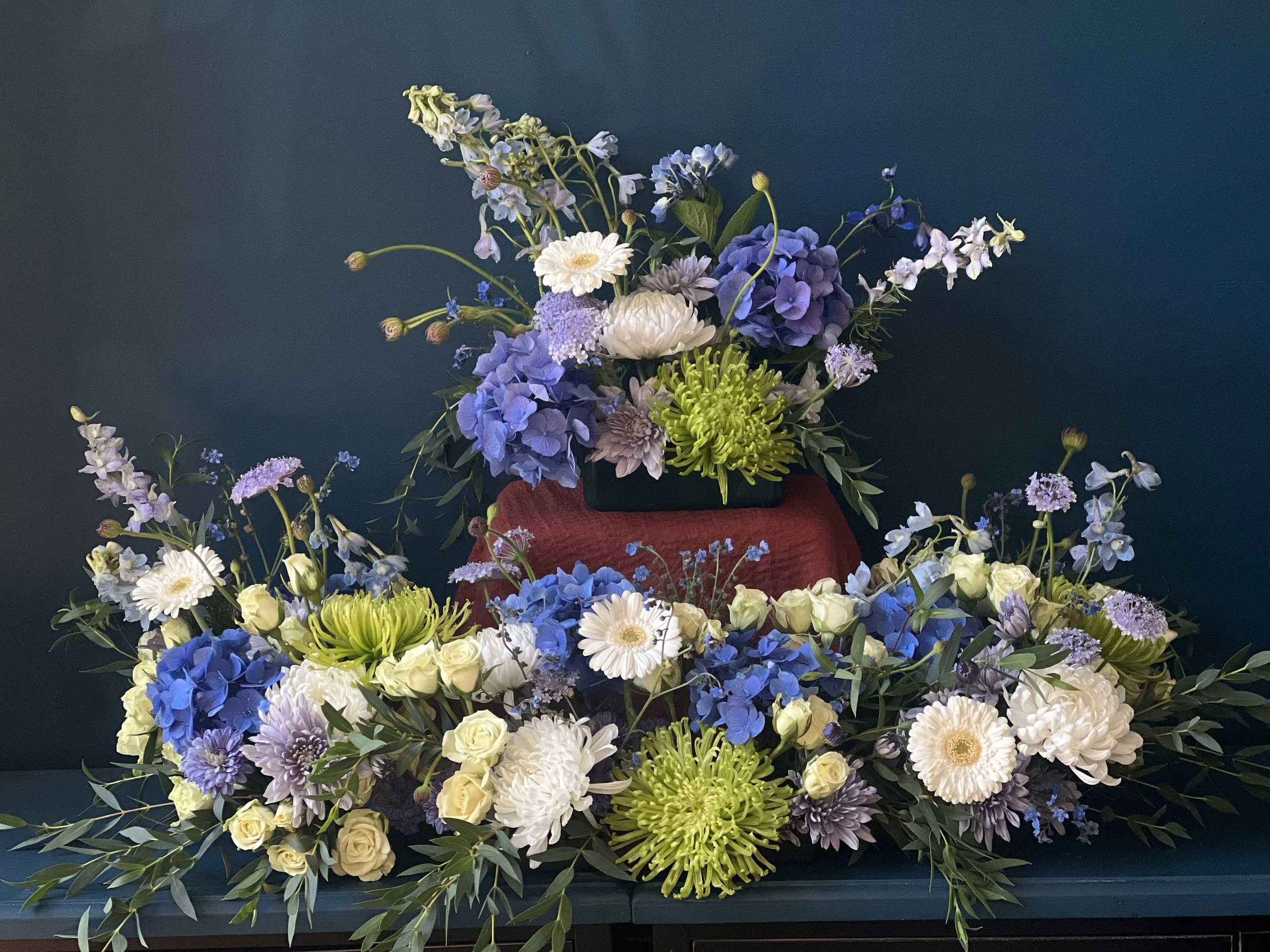 Celebration of life floral design for a Portland funeral, designed with green, white and blue blooms by Portmanteau