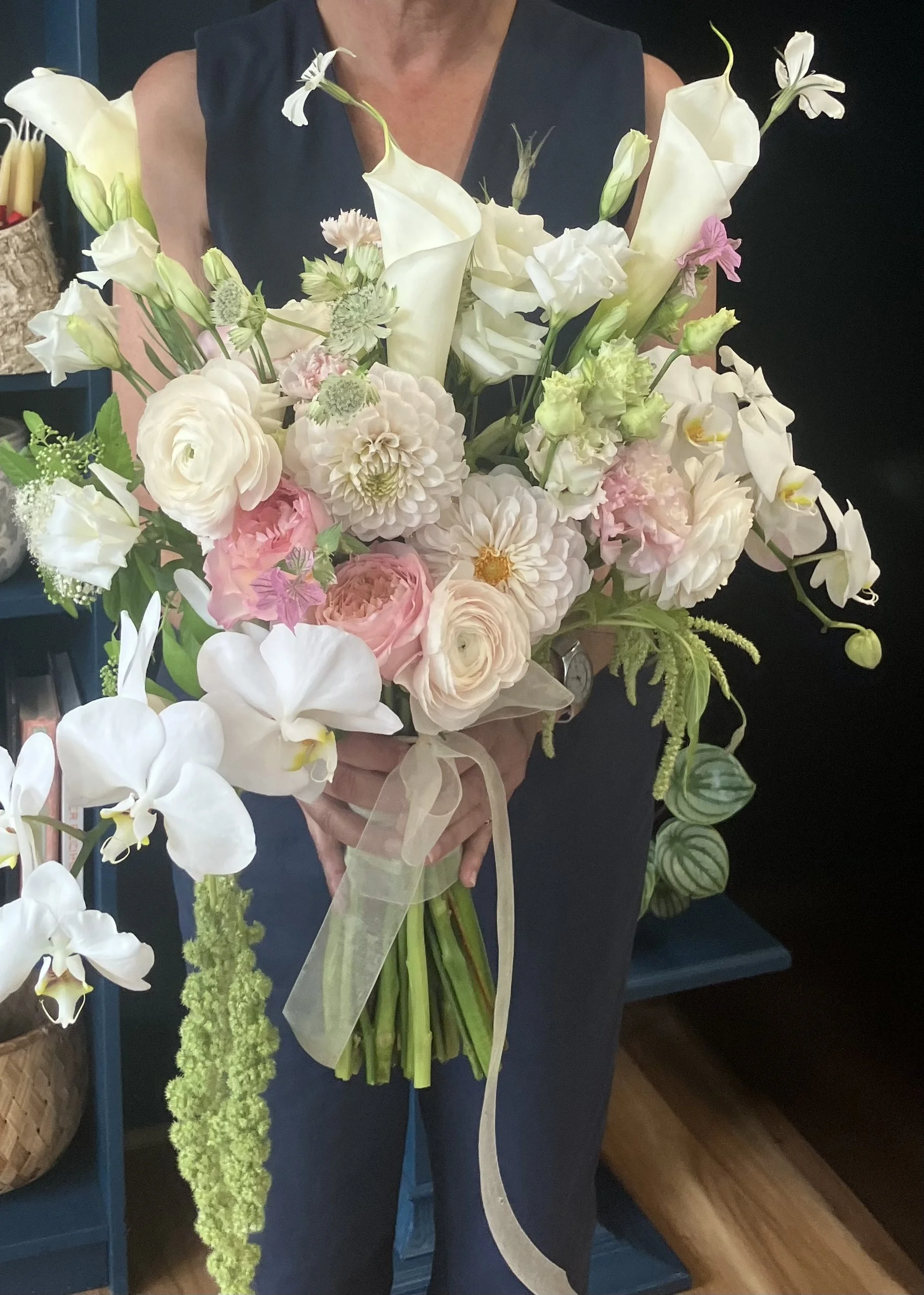 A bridal bouquet in exquisite pale colors designed with roses, dahlia, orchids for a Portland wedding