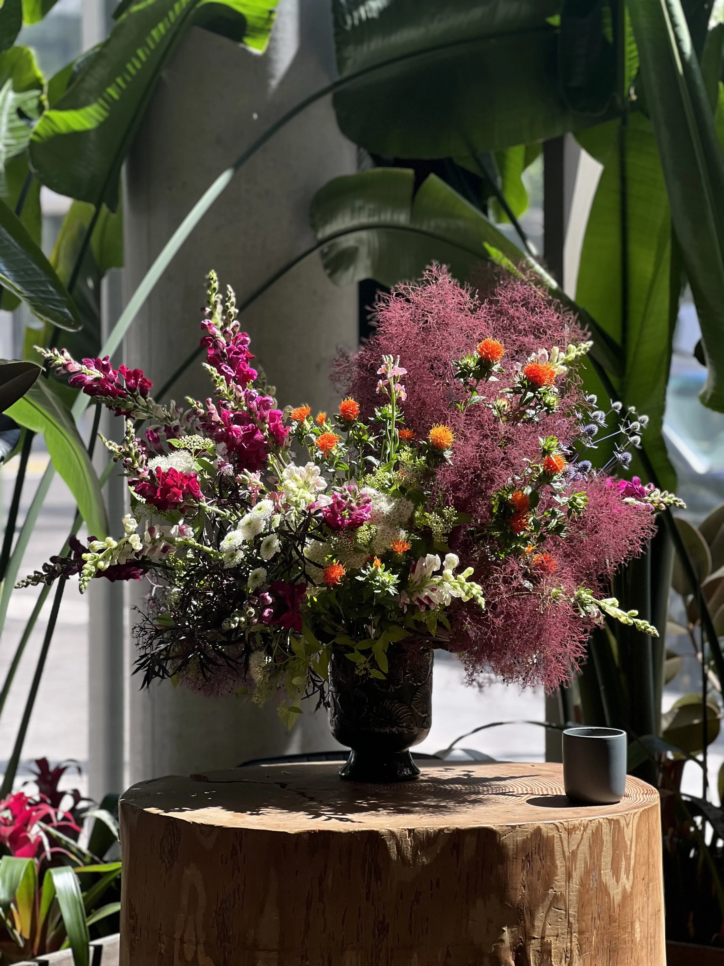 A floral arrangement for a reception area at a local business, made with snapdragons and smokebush, designed as a subscription service