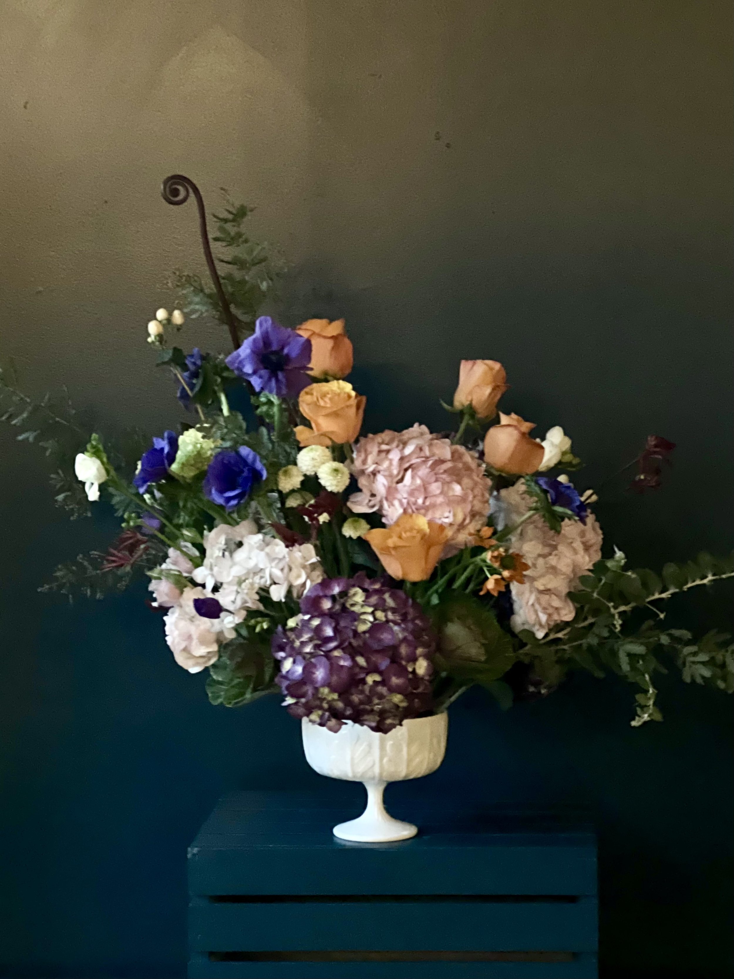 Spring collection of hydrangea with orange roses and blue anemones designed in a compote