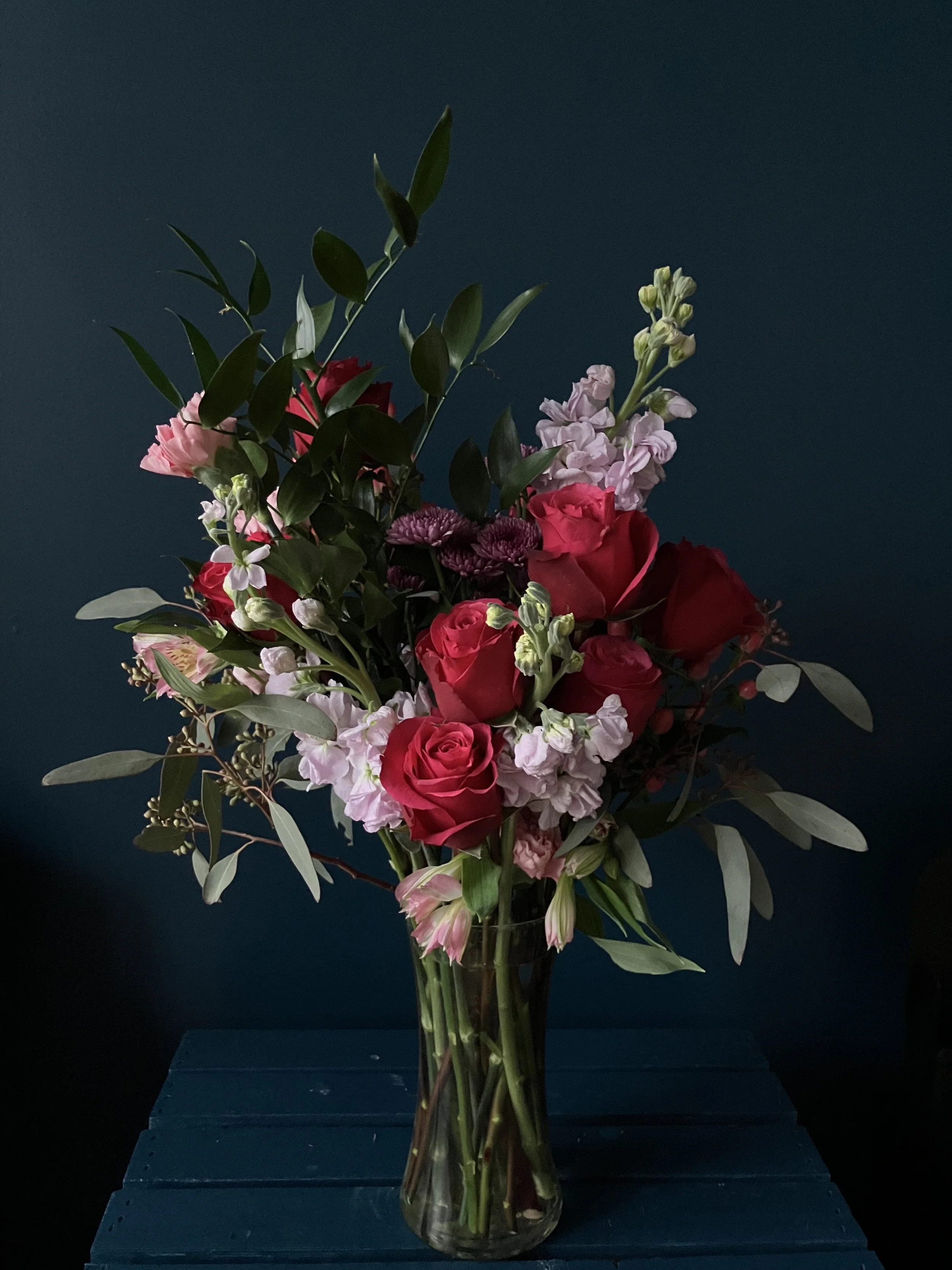 Classic Valentine's bouquet made in Portland featuring red roses, purple stock, pink carnations, and eucalyptus