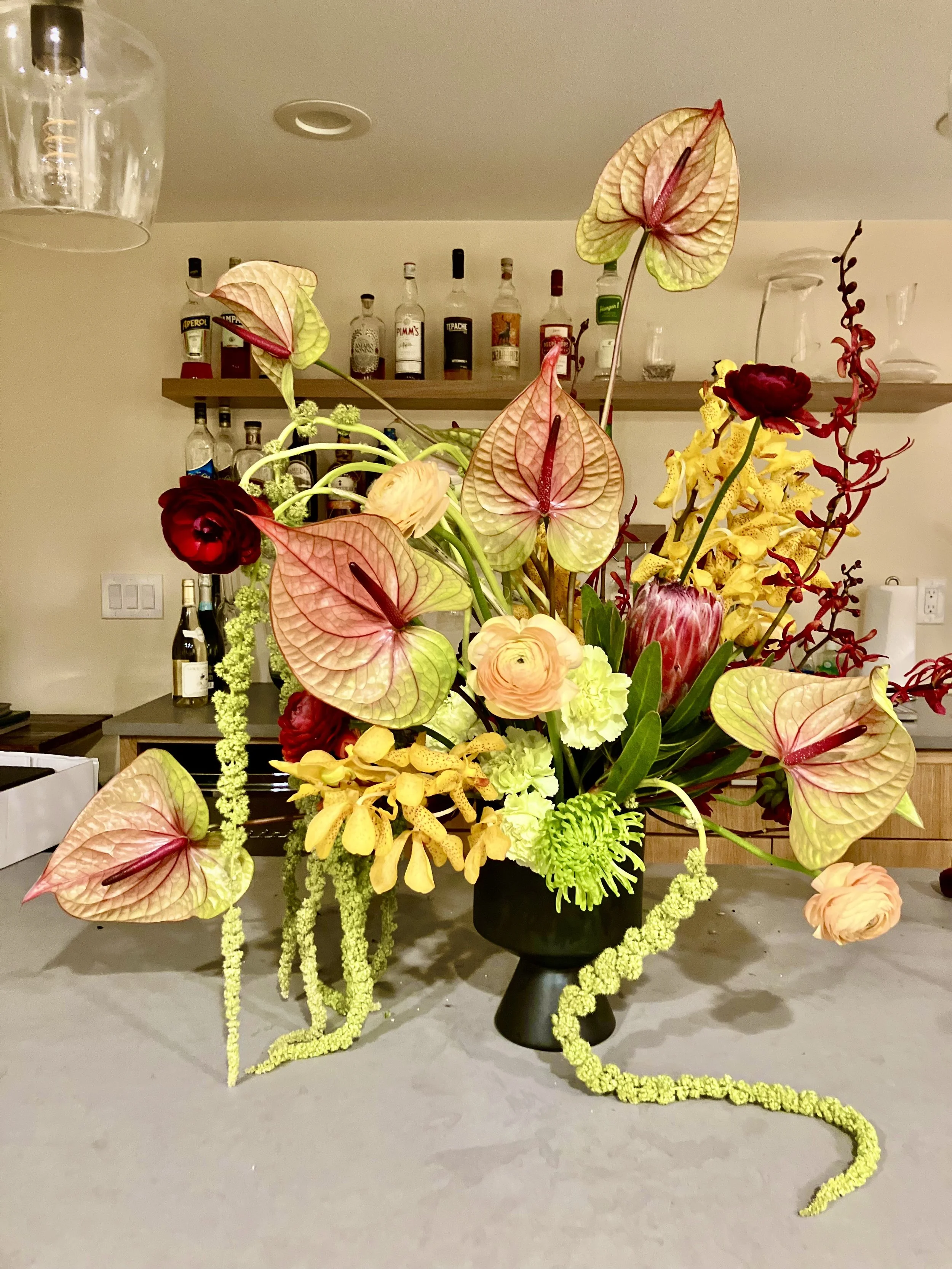 An arrangement using flowers we hadn't used before, like tequila anthurium, yellow orchids, and green amaranth, designed for a Portland home in the Arbor Lodge neighborhood