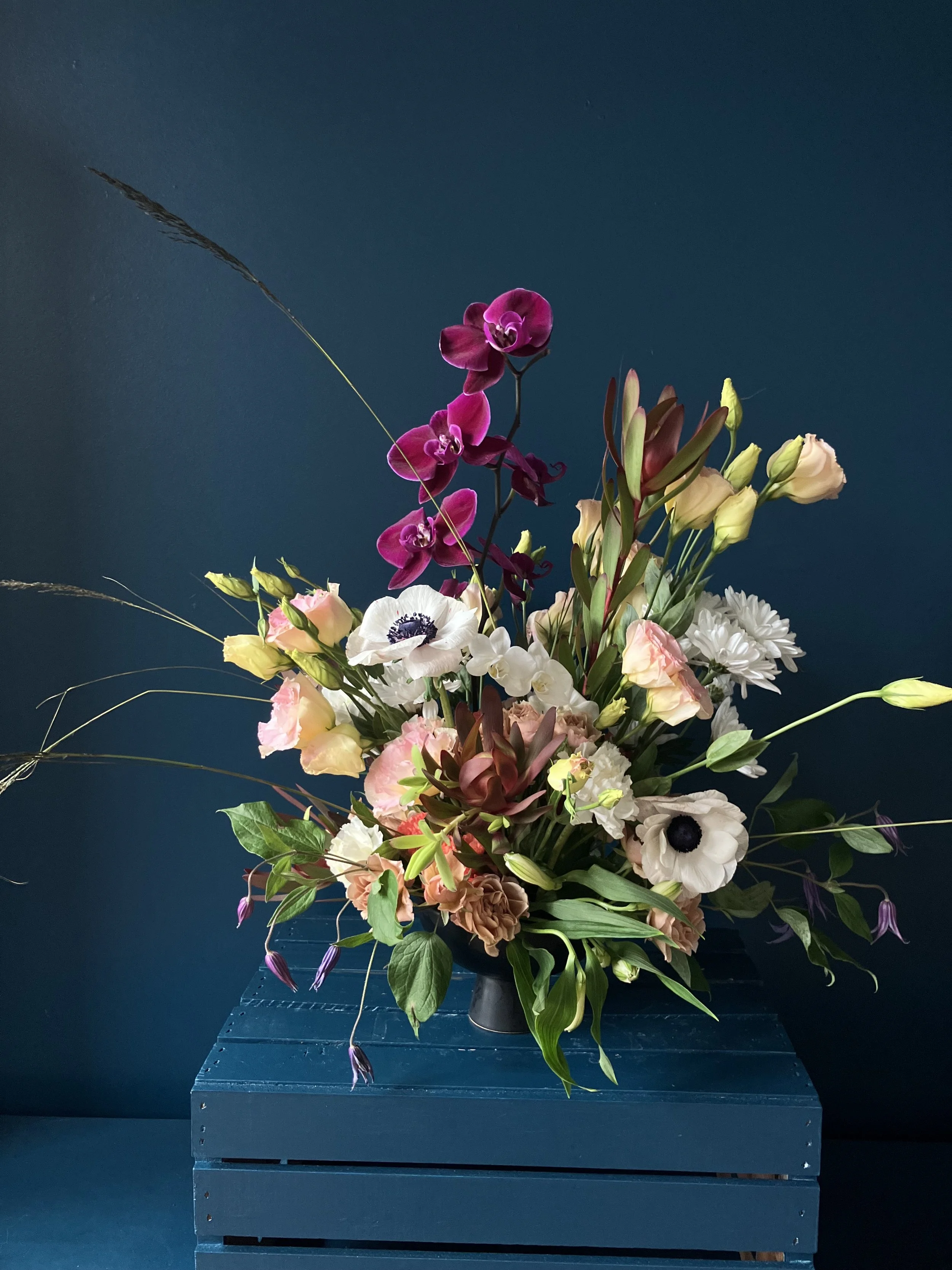 Phalaenopsis arching over stems of beautiful peach lisiantha