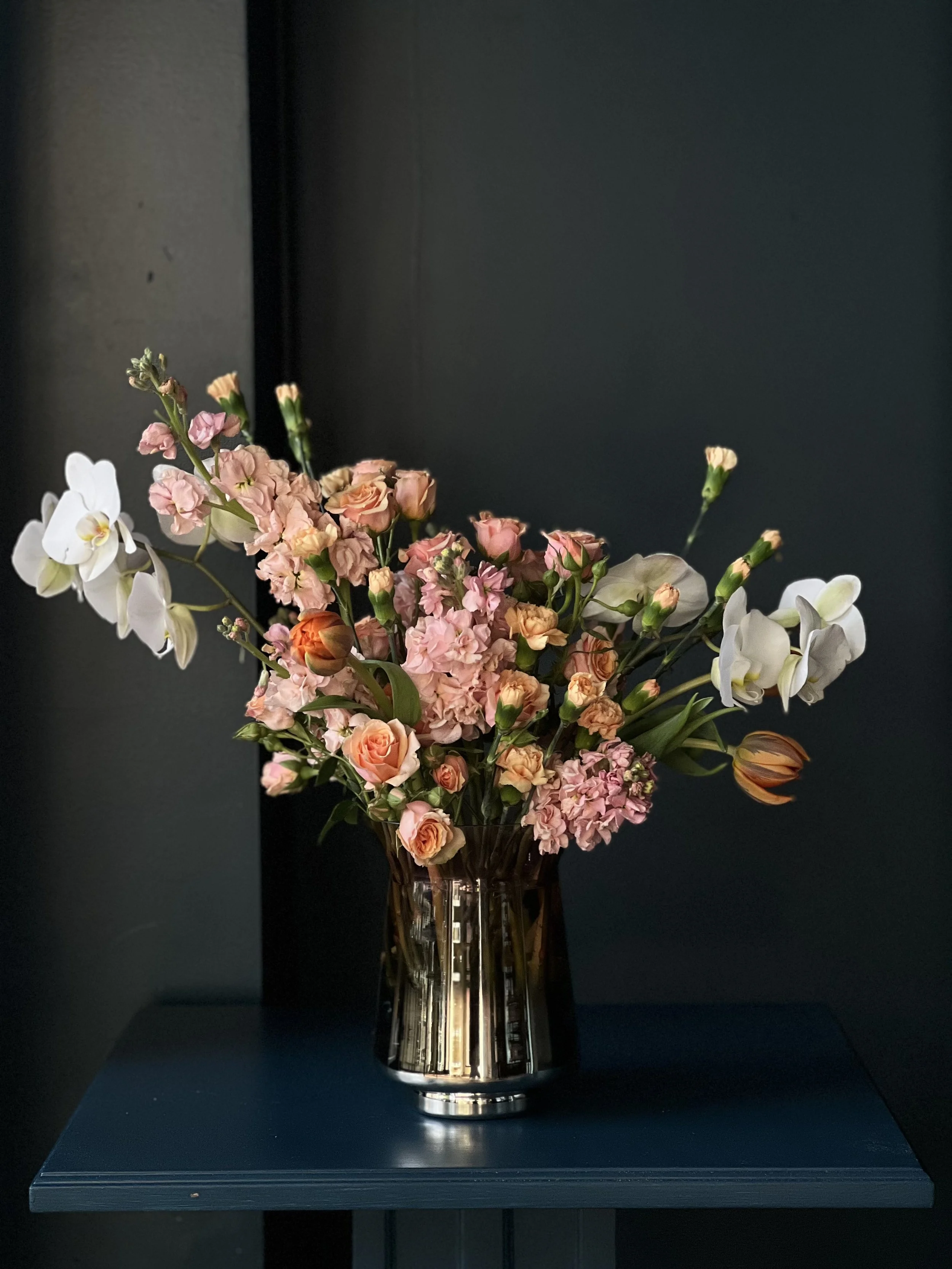 Modern, romantic Valentine's Day floral arrangement in blush colors, designed with orchids, tulips, and roses