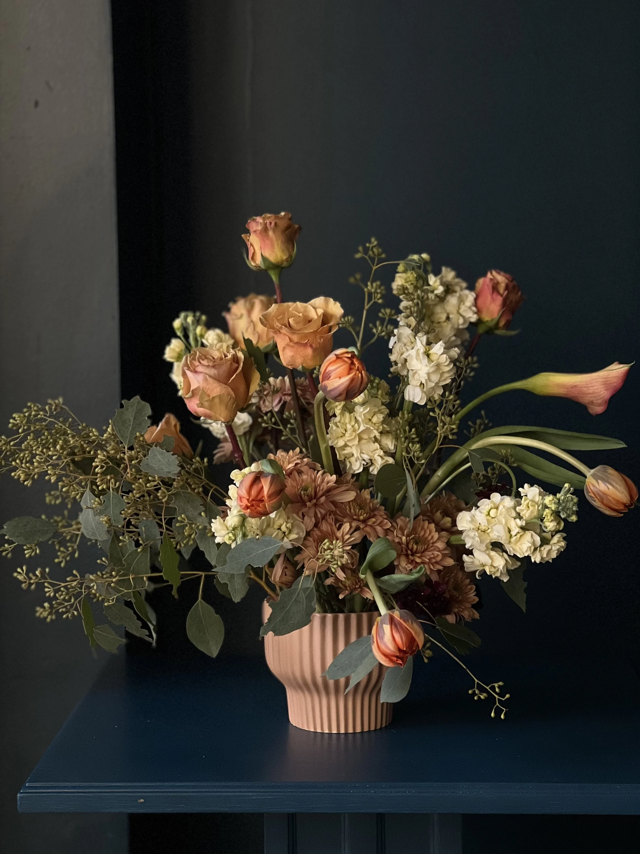 Blush colored roses, calla lilies and tulips with white stock and eucalyptus form this arrangement for Portland delivery