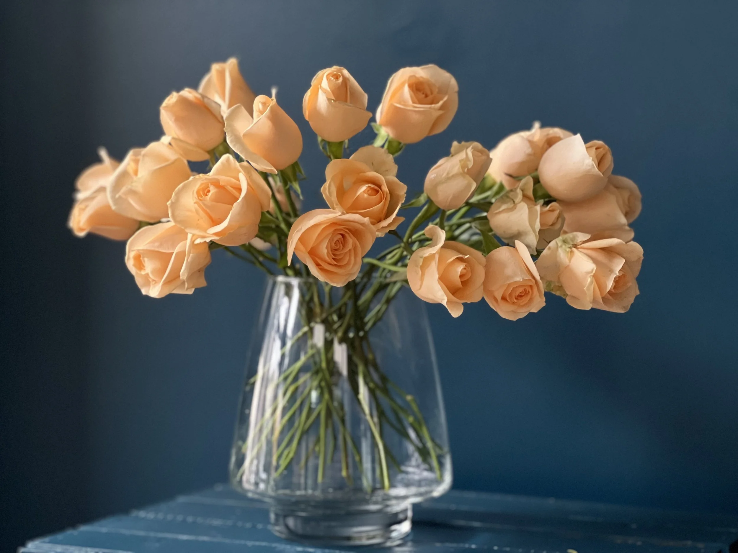 Just a bunch of peach colored roses in clear vase