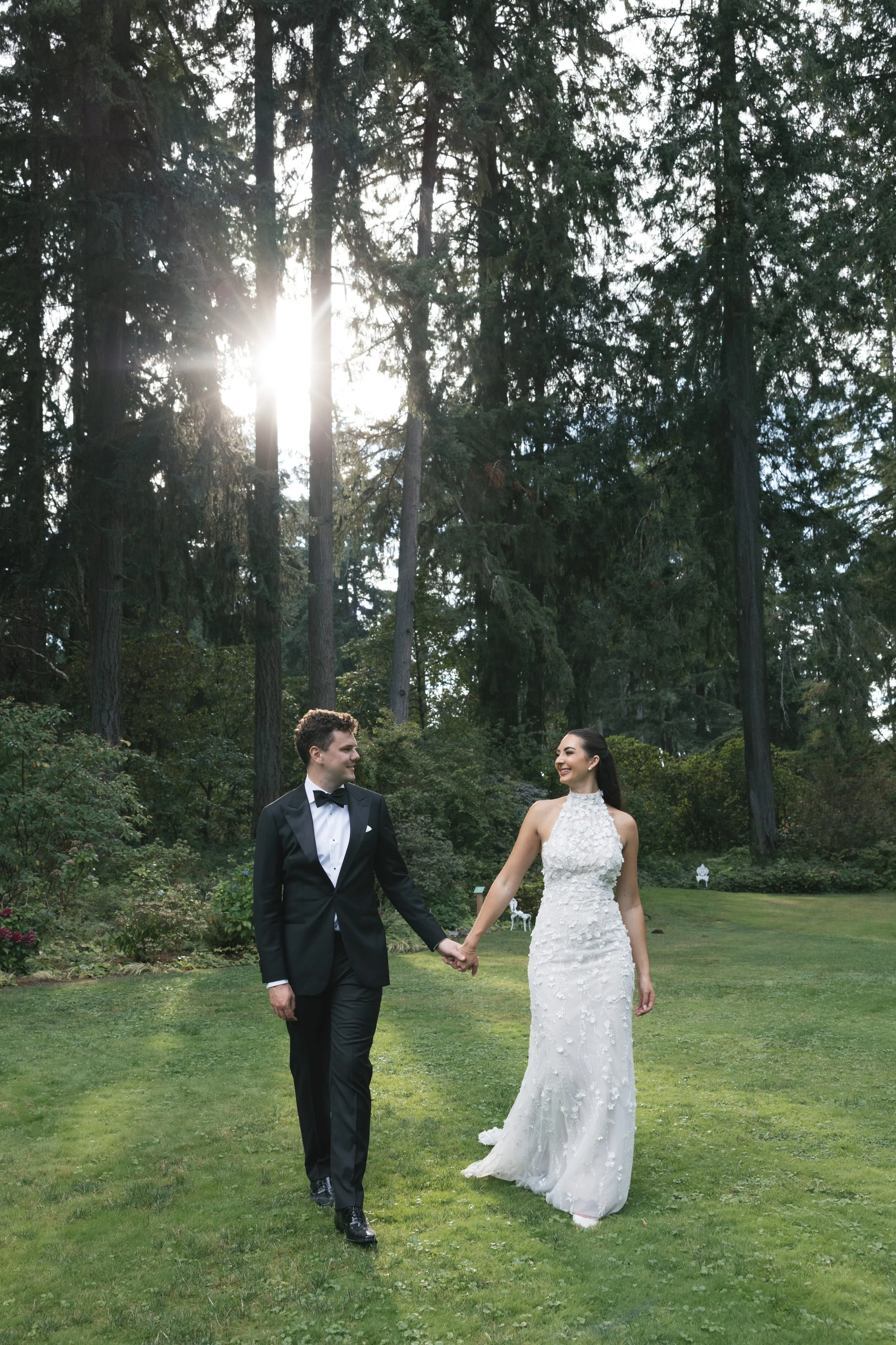 bride and groom walking through manicured gardens