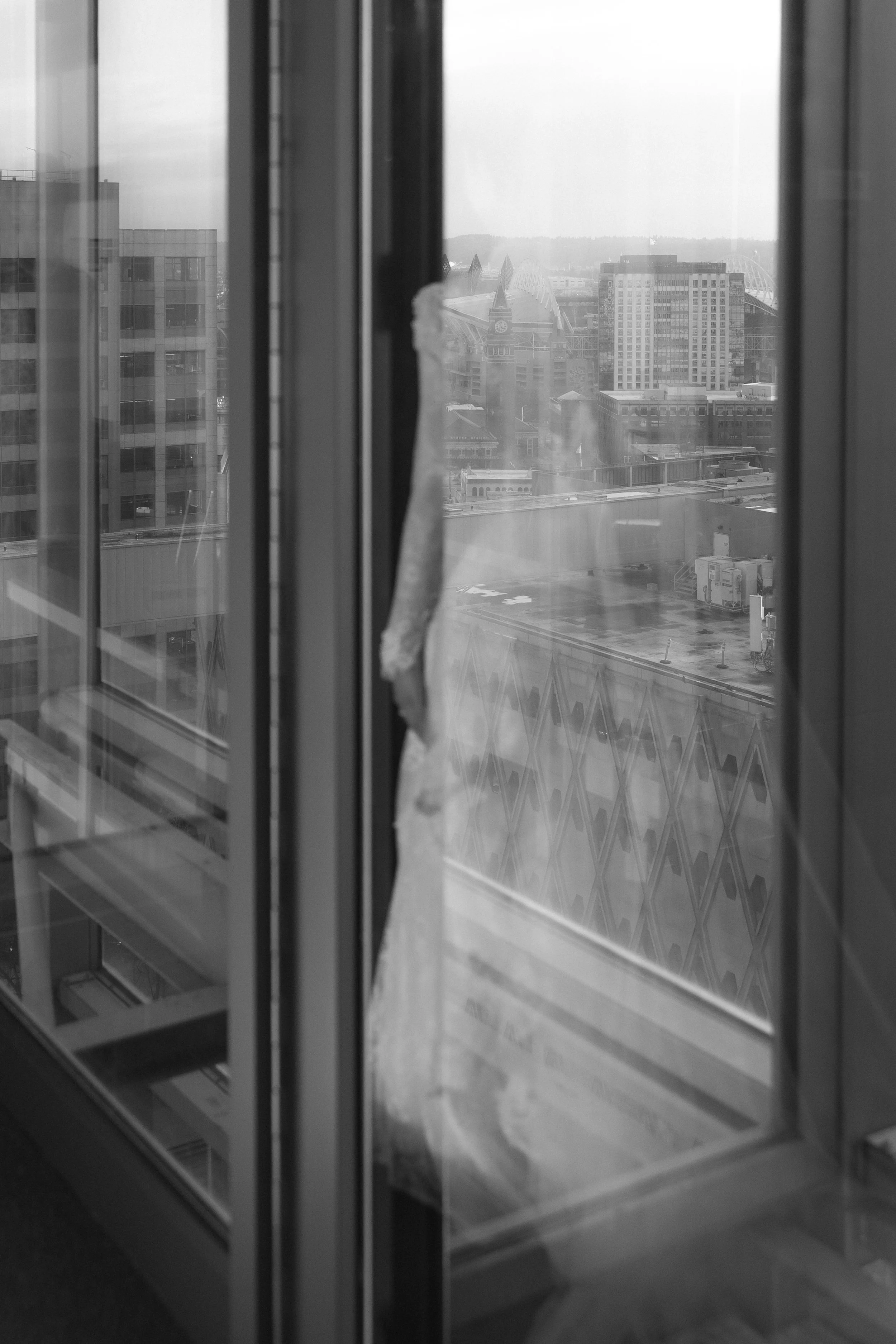 Cityscape view through a broken glass door on a foggy day.