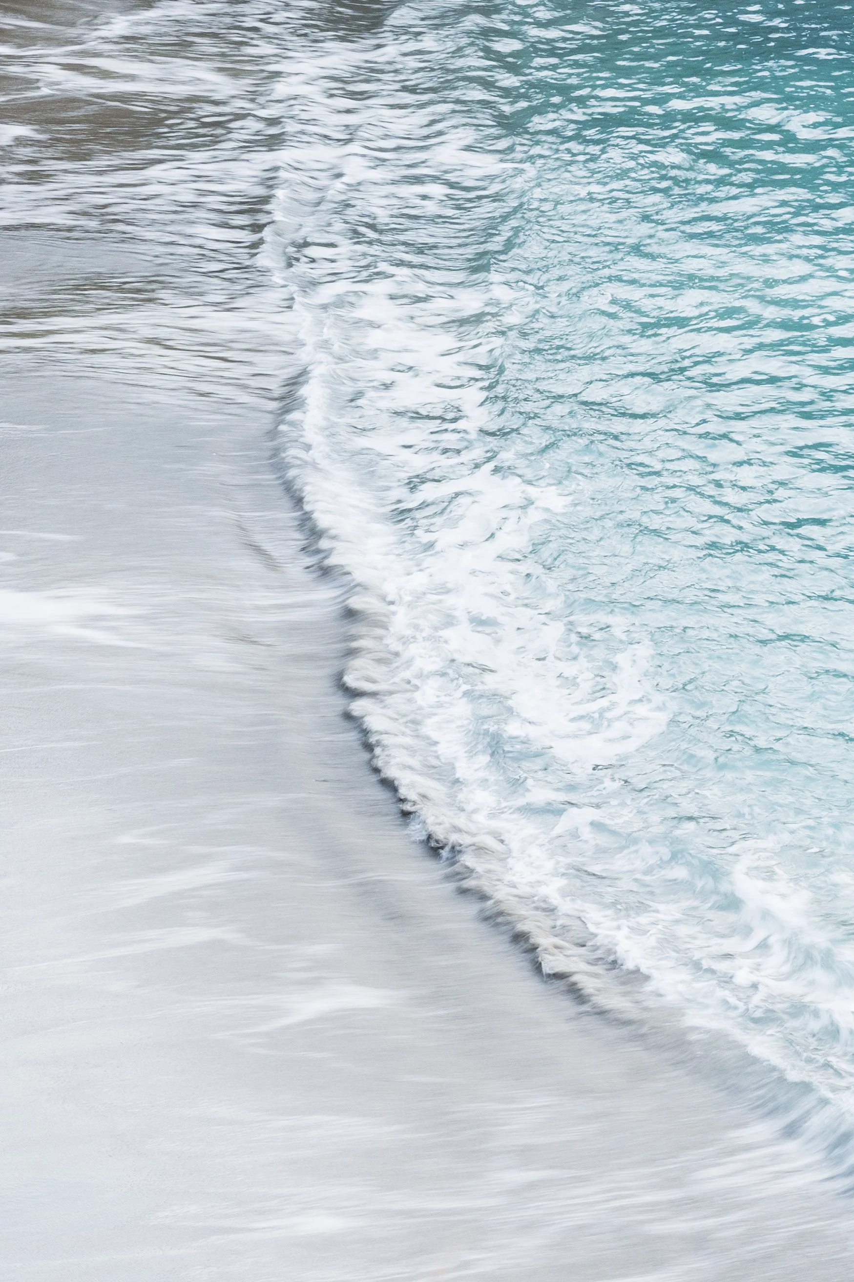 Waves crashing on the shore of a sandy beach on a sonoma coast wedding venue.