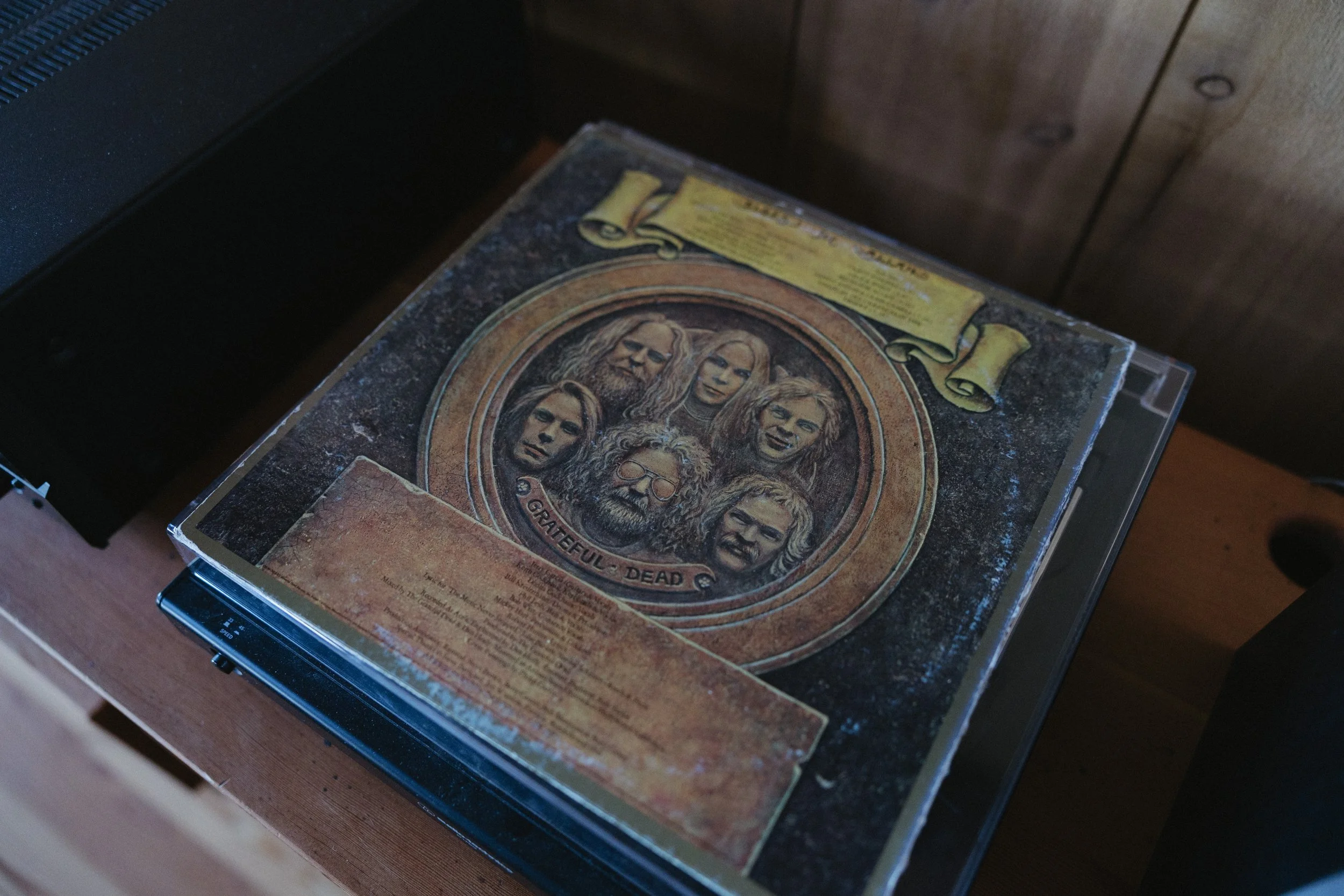 A cassette tape case featuring the band Grateful Dead with illustrated portraits of seven band members on the cover.