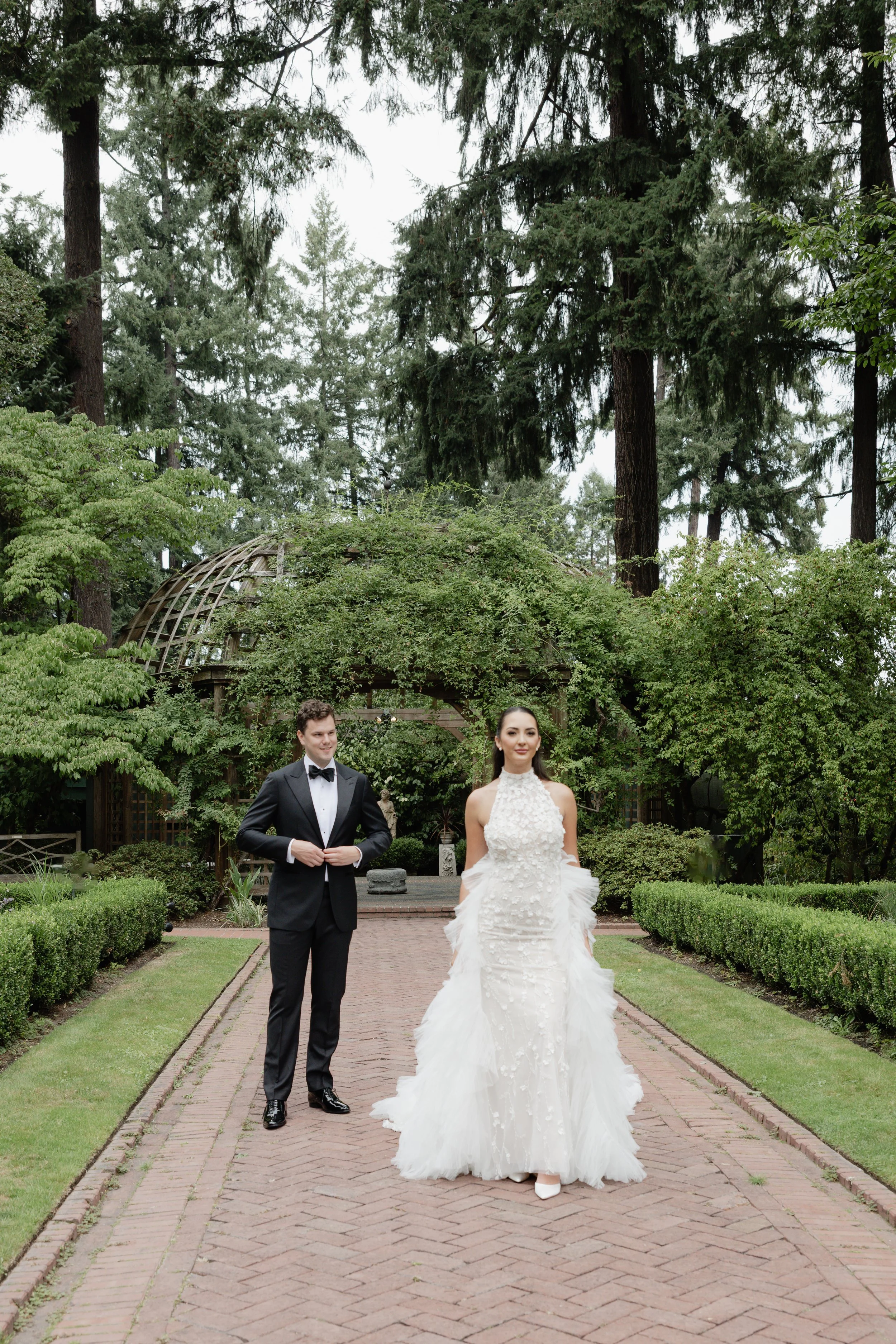 bride and groom beneath towering trees