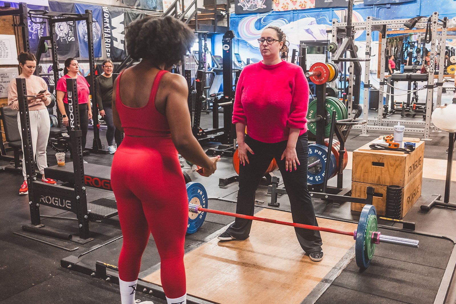 Ada coaching a woman on deadlift form at a Seattle area gym — 1:1 personal training