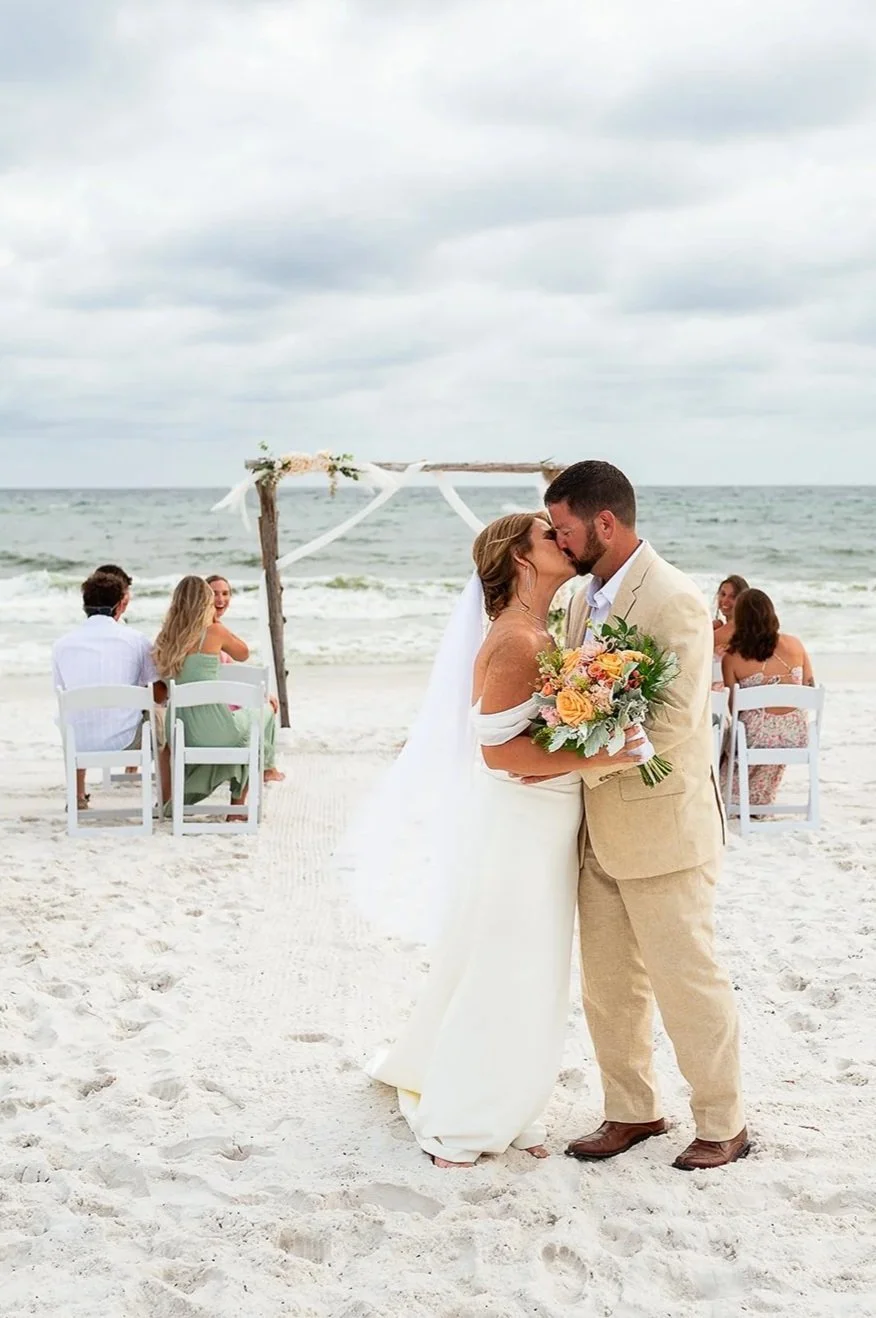 Couple celebrating their anniversary with a vow renewal surrounded by family on Destin Beach