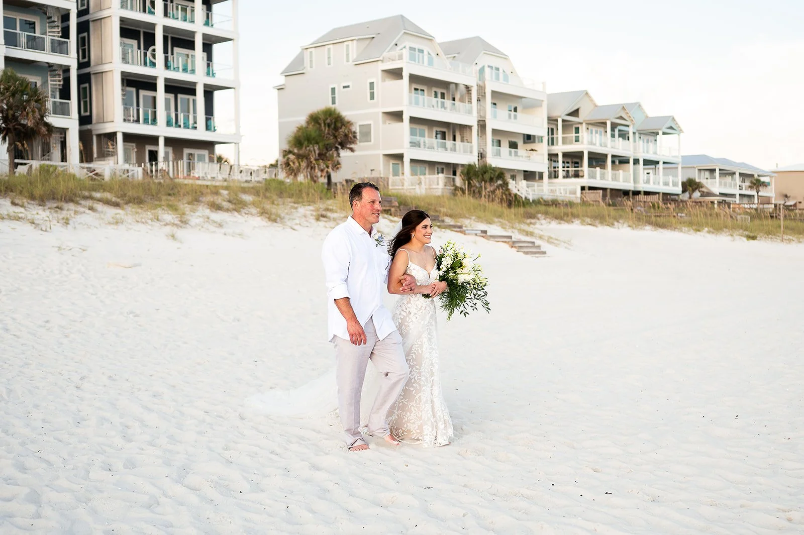 father of brade walking daughter down inlet beach to meet her soon to be husband to exchange vows at sunset along the gulf coast shores along hwy 30a