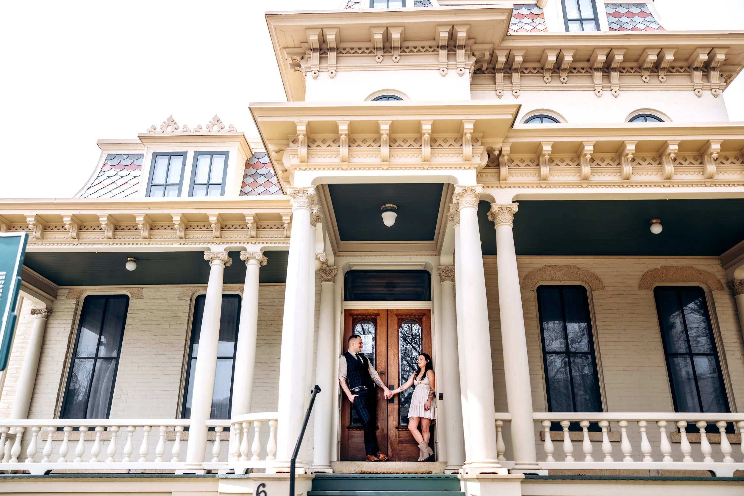 Victorian-style house with two people on porch